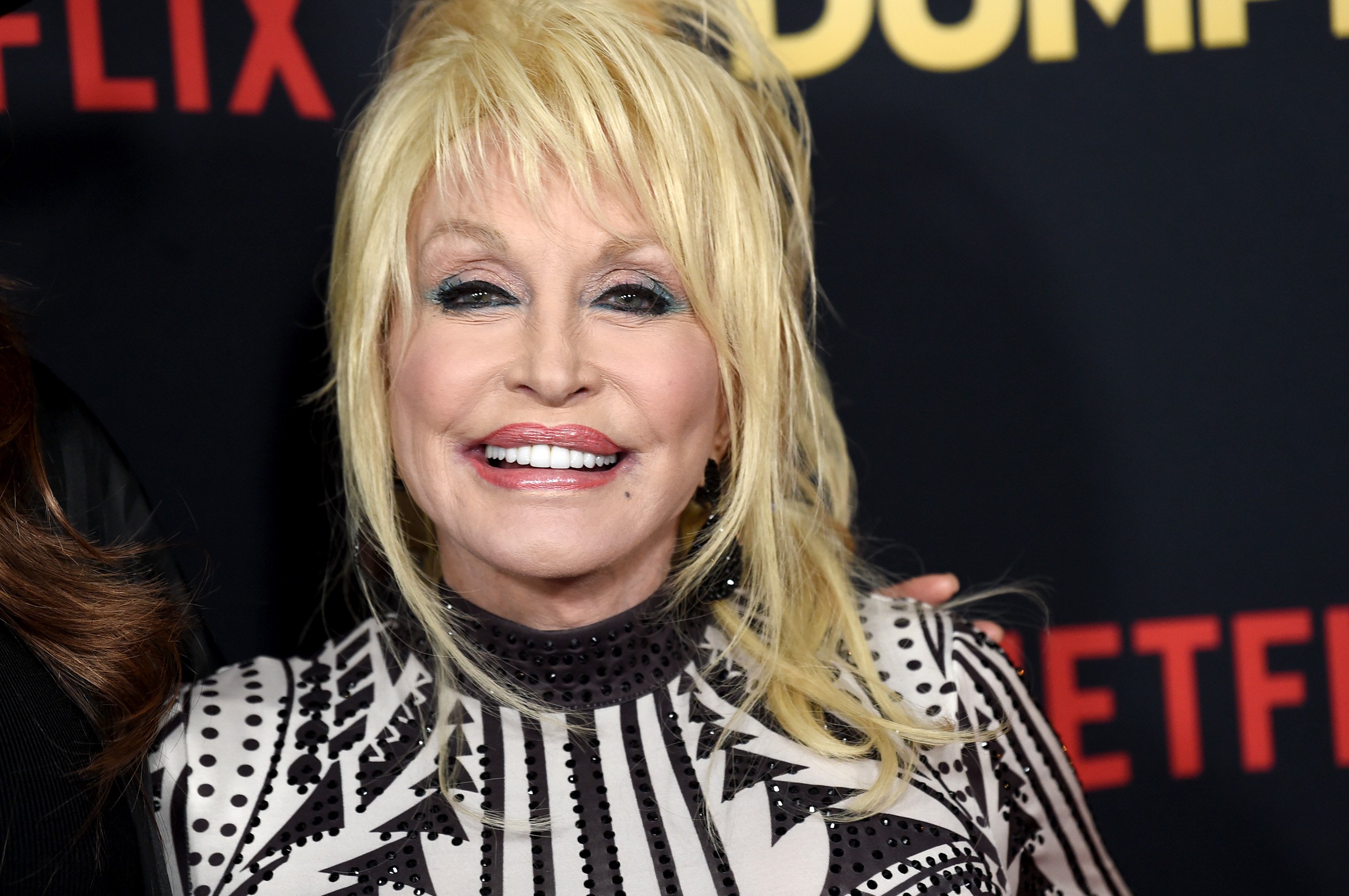 Dolly Parton smiles while attending a premiere of Netflix's 'Dumplin' in 2018