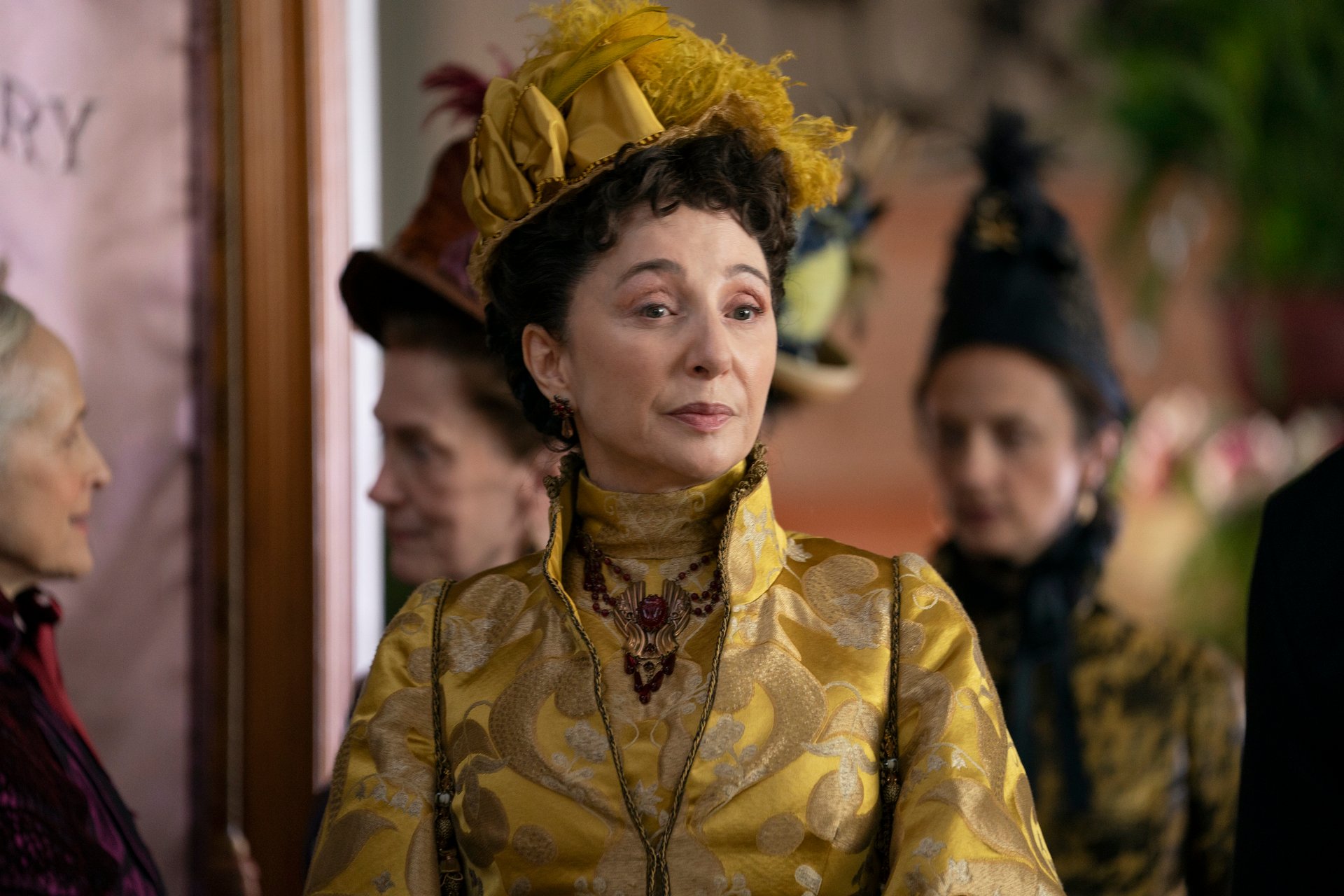 Donna Murphy as Mrs Astor, wearing a yellow gown and hat, in 'The Gilded Age'