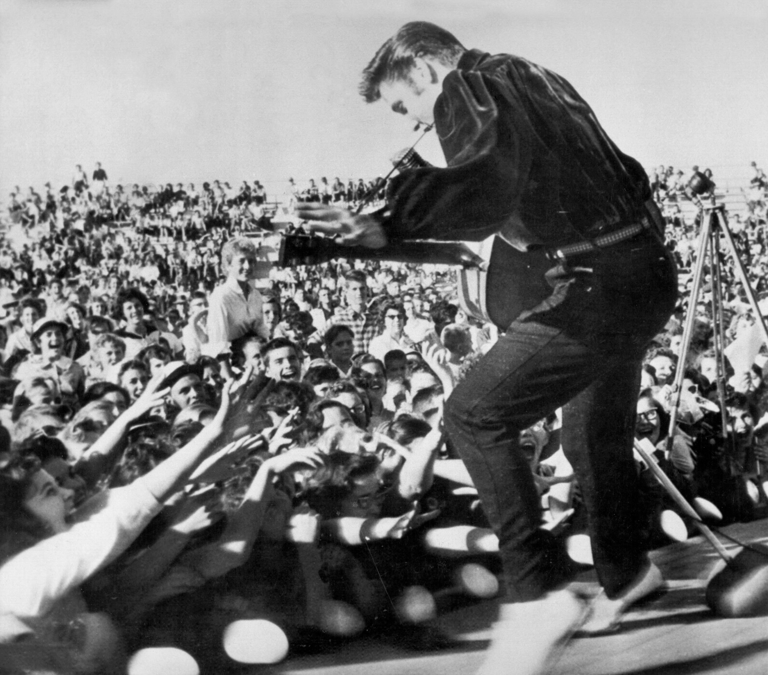 Elvis Presley performing a song in front of fans