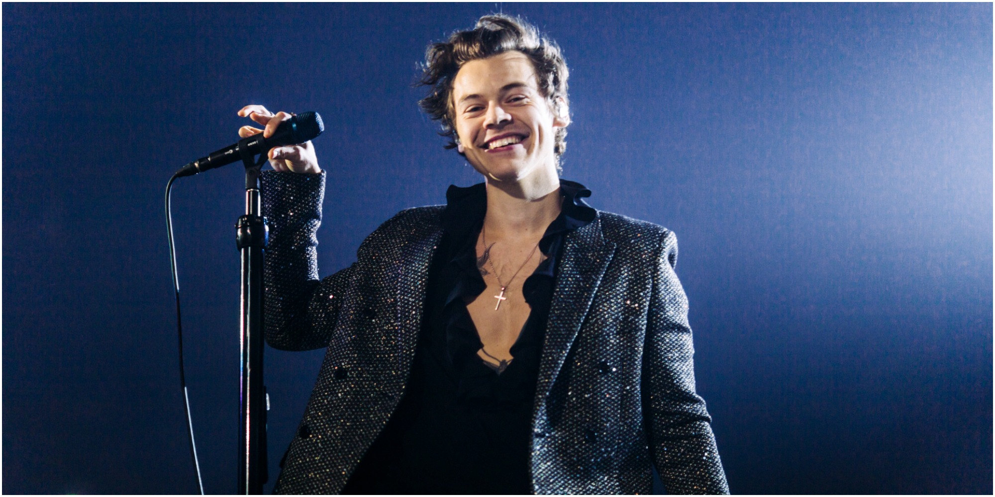 Harry Styles singing on stage wearing black leather during his European Tour.