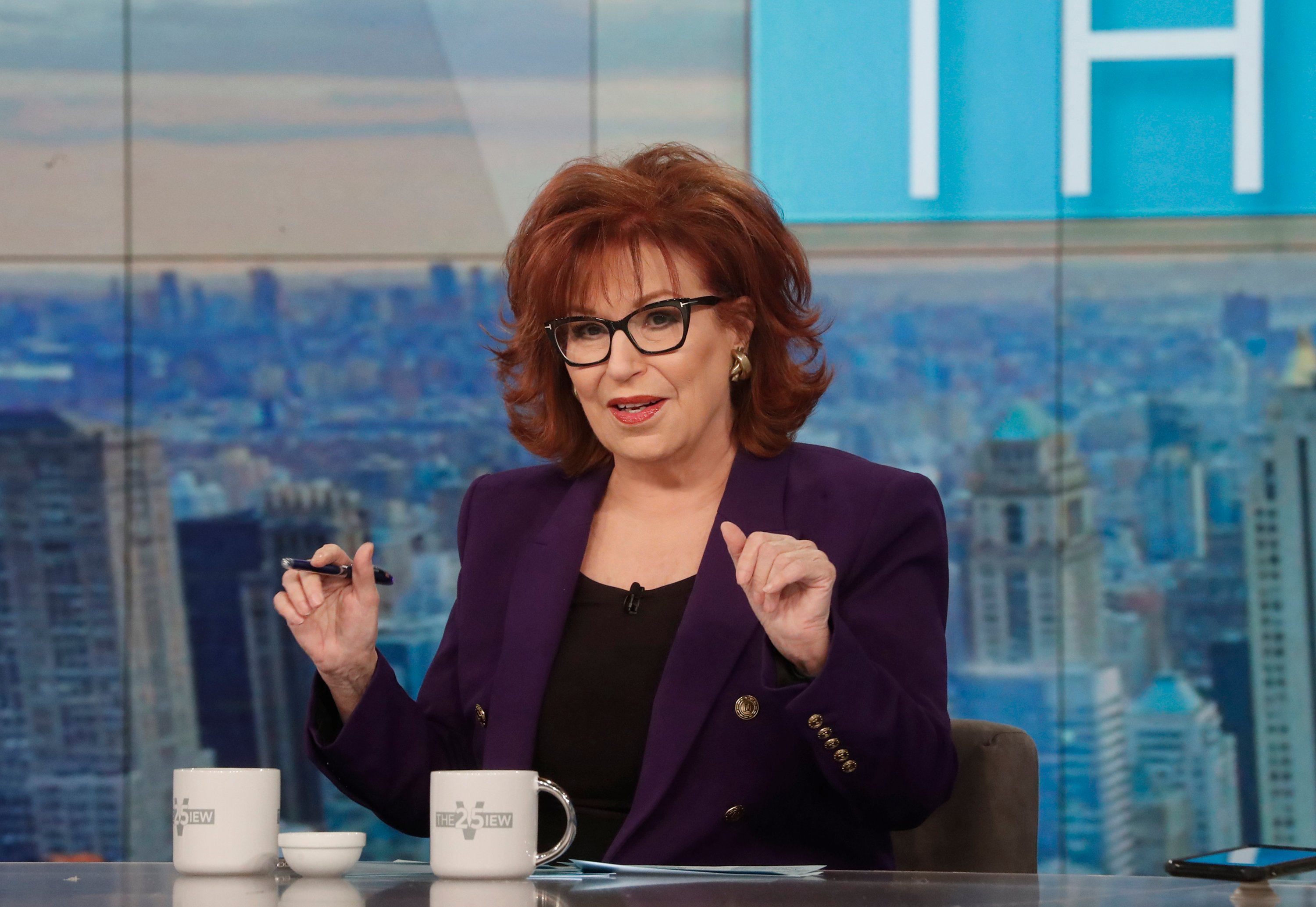 Joy Behar in the middle of a debate, wearing a purple blazer and black blouse on the set of 'The View'