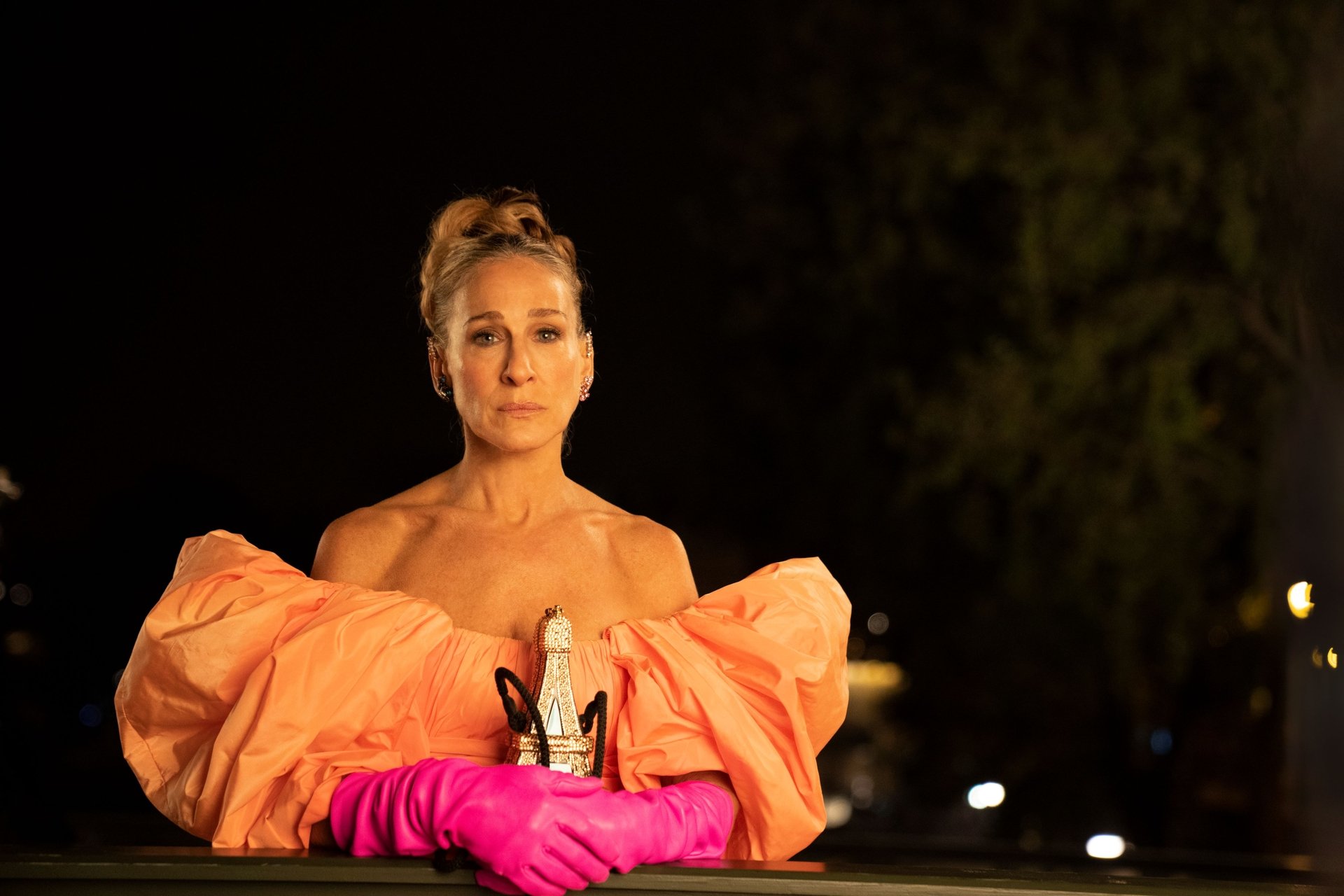 Sarah Jessica Parker, as Carrie Bradshaw, stands on the bidge in Paris while filming 'And Just Like That...'