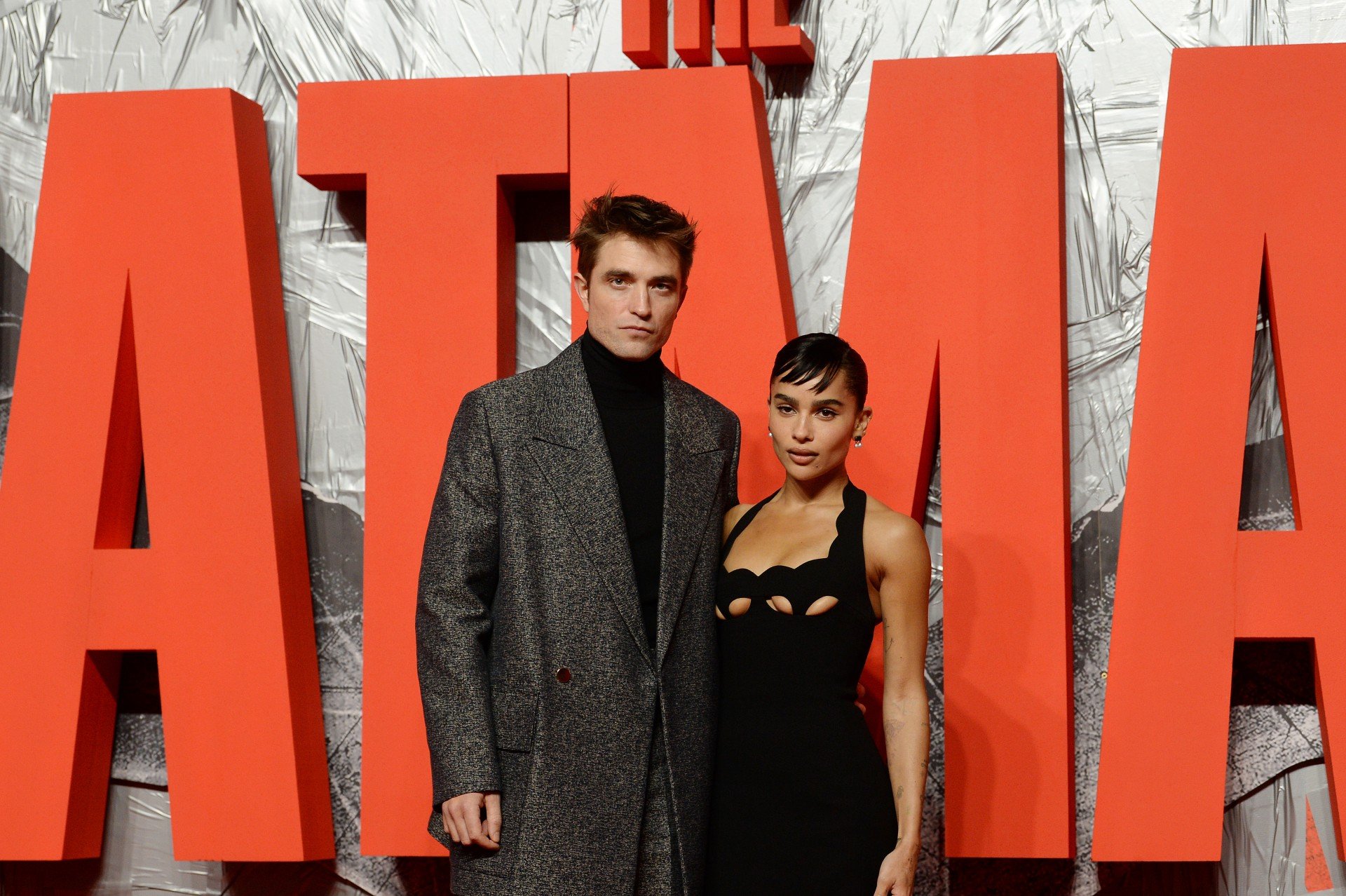 Robert Pattison and Zoe Kravitz pose in front of The Batman sign at the movie premier.