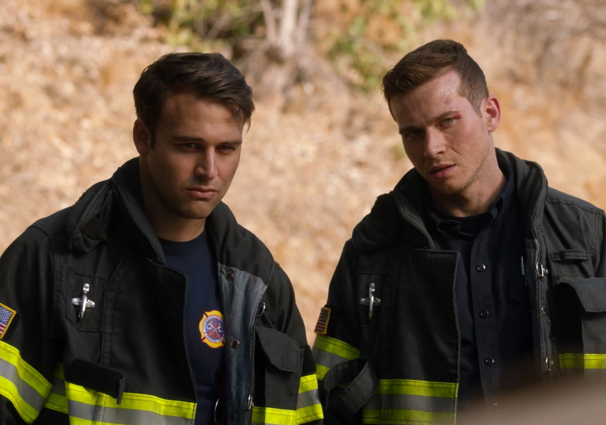 '9-1-1' Season 5 cast members Eddie Diaz and Buck in firefighting gear looking at something in front of them