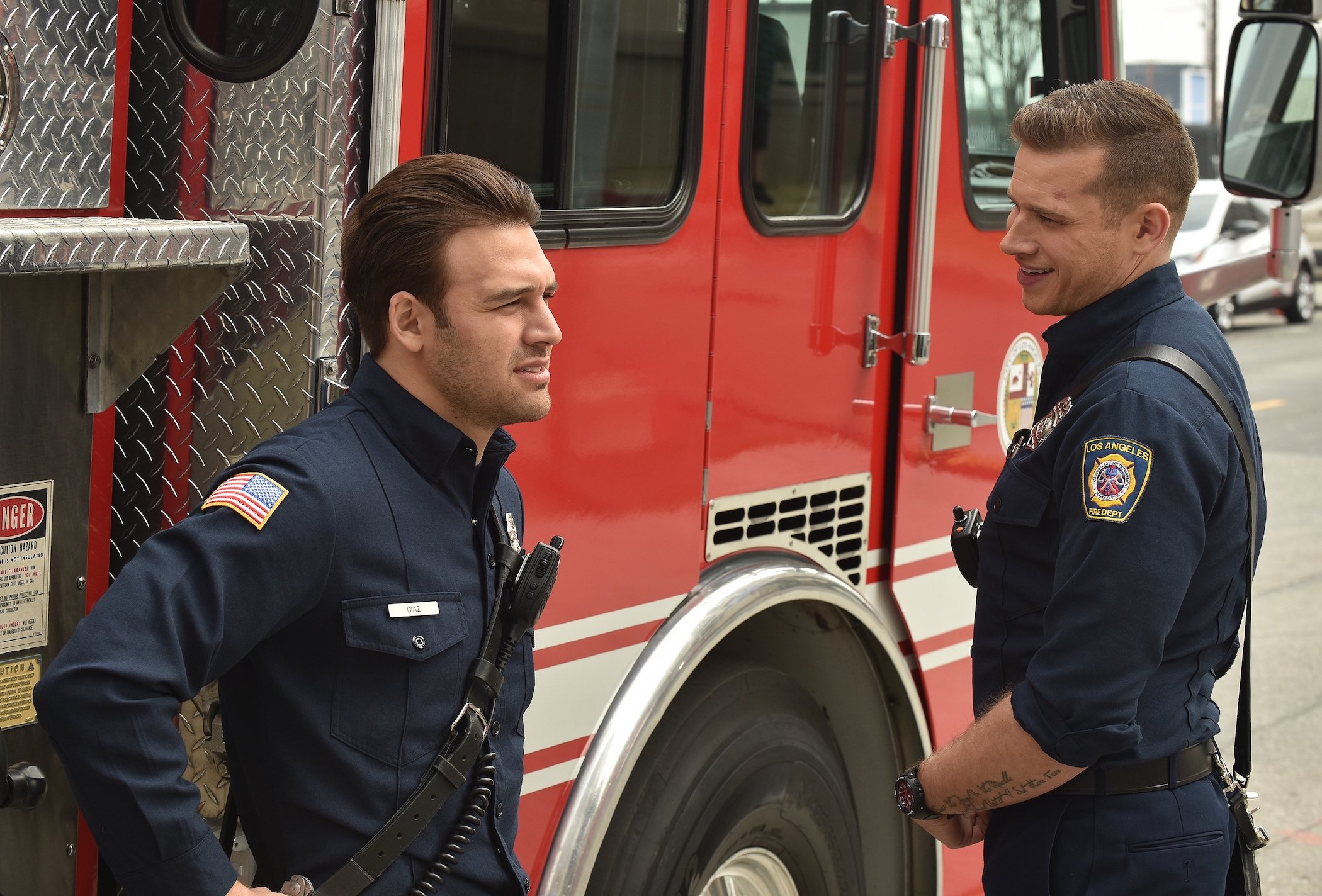 Eddie Diaz and Buck talking and laughing next to a firetruck in '9-1-1'