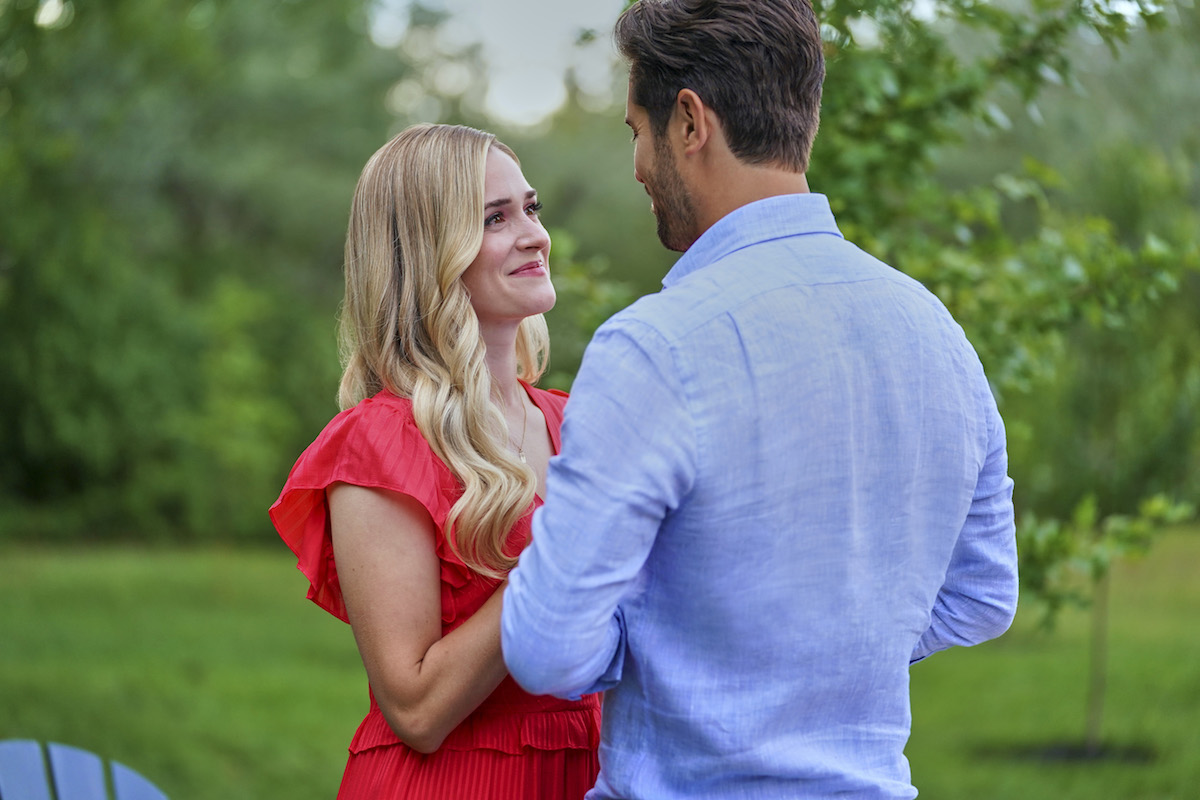 Brittany Bristow, in red, facing a man wearing a blue shirt in Hallmark's 'A Tail of Love'