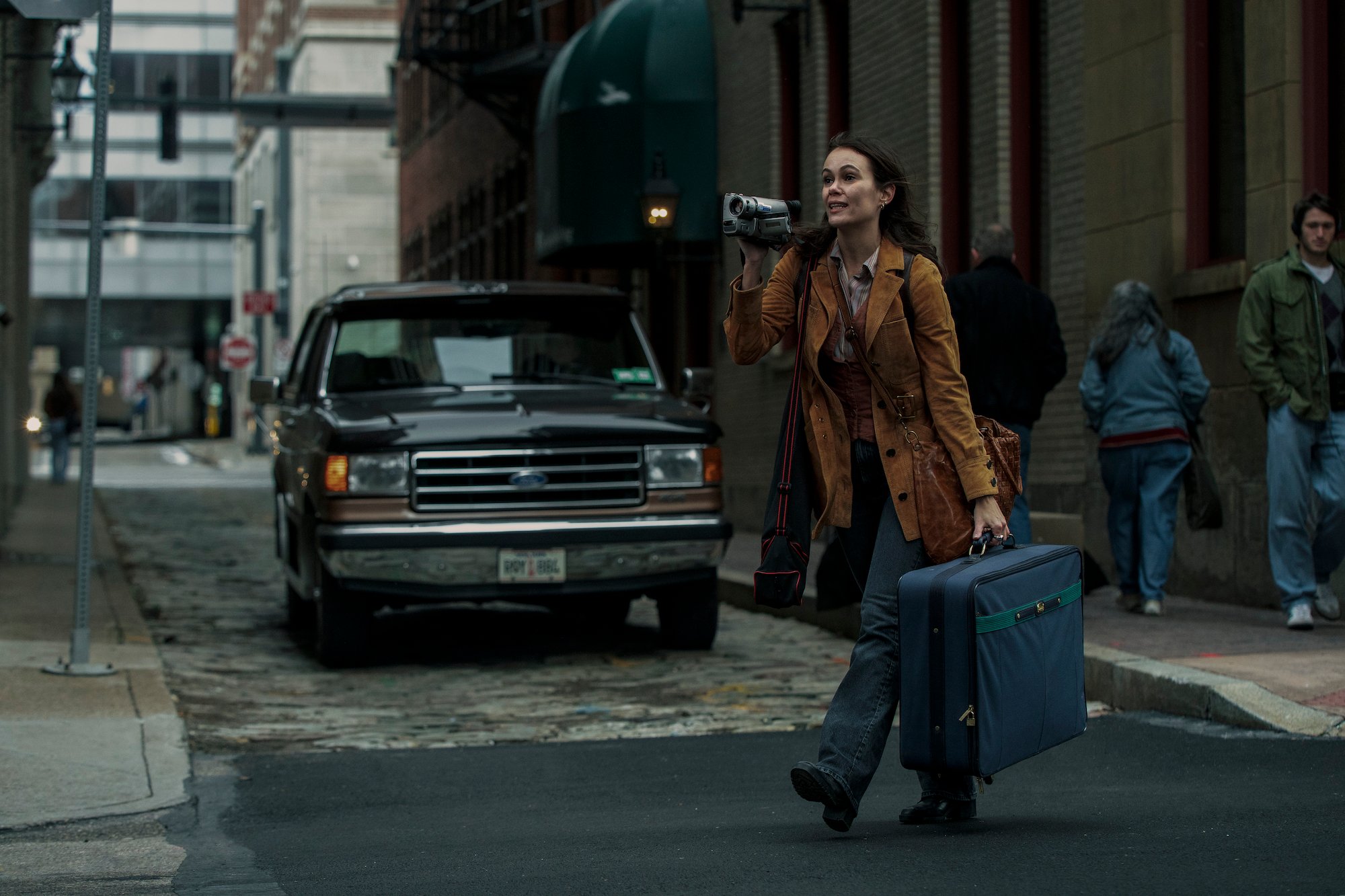 'Archive 81' makeup artist Etzel Ecleston used subtle looks to hint to viewers Melody Pendras moved into The Visser in the '90s. Melody, played by Dina Shihabi, is seen here holding a suitcase and a camera as she walks across the street.