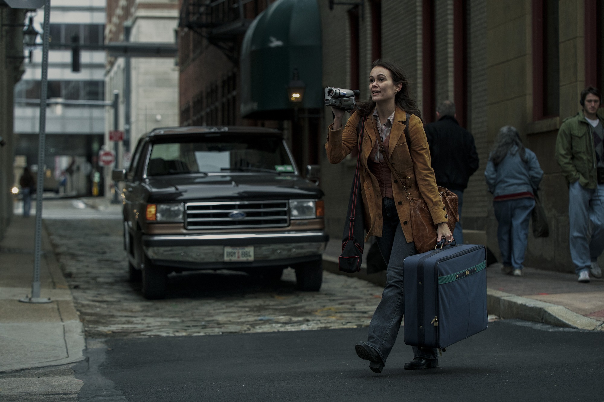 'Archive 81' makeup artist Etzel Ecleston used subtle looks to hint to viewers Melody Pendras moved into The Visser in the '90s. Melody, played by Dina Shihabi, is seen here holding a suitcase and a camera as she walks across the street.