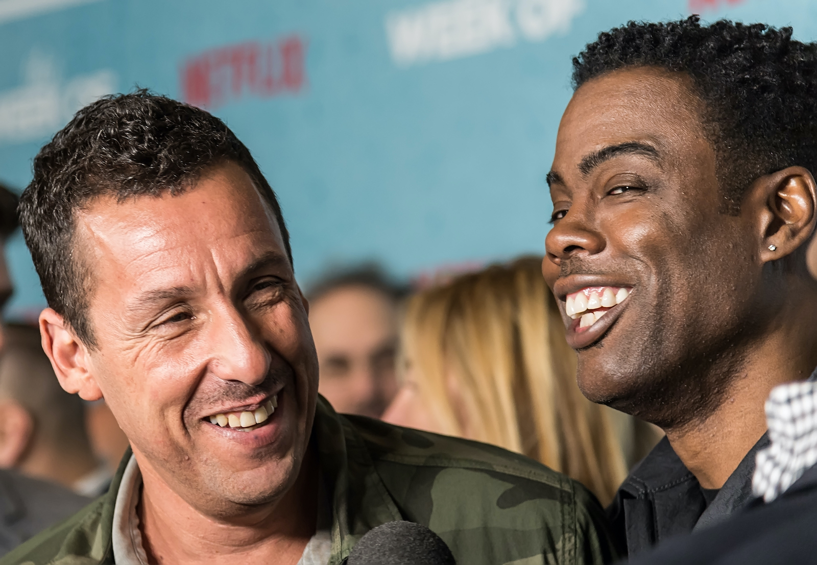 Adam Sandler and Chris Rock laugh together during a movie premiere