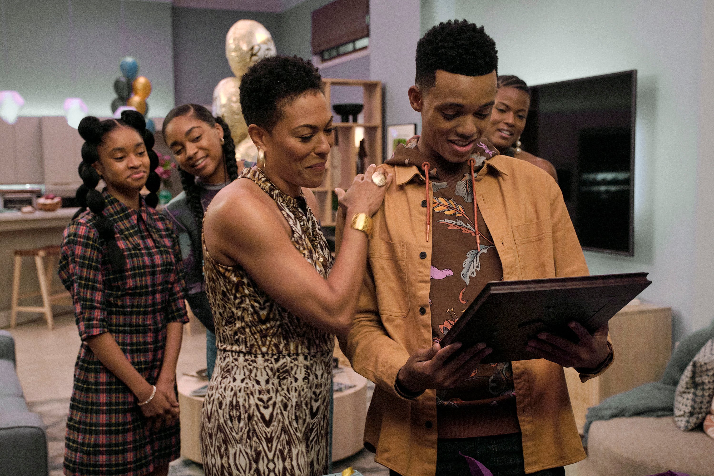 Akira Akbar, Simone Joy Jones, April Parker Jones, Jabari Banks, and Cassandra Freeman standing as Banks stares at a picture