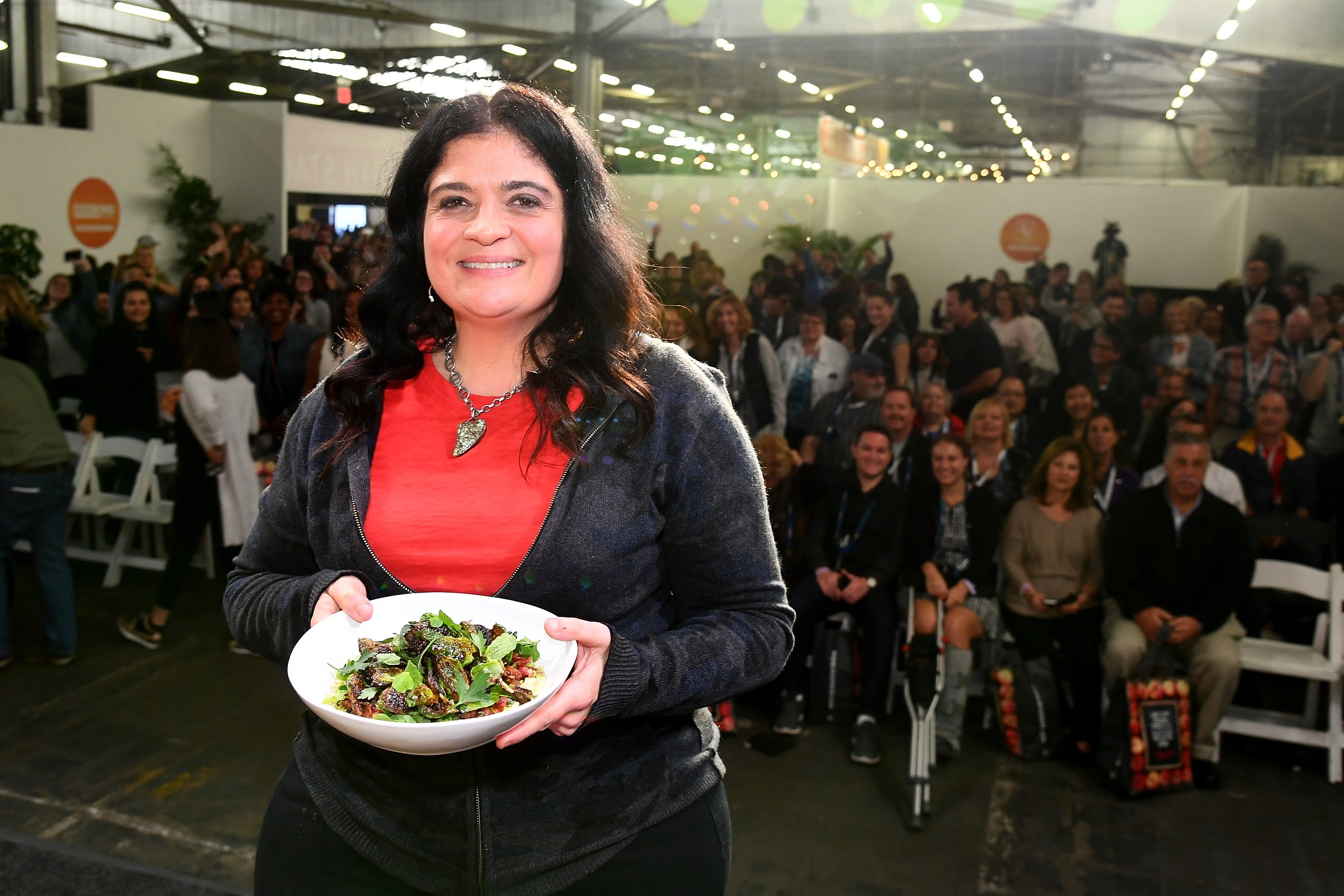 Food Network personality Alex Guarnaschelli wears a red blouse in this photograph.