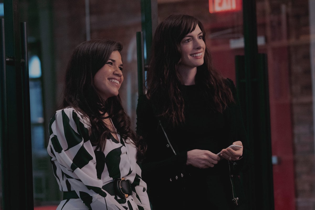 America Ferrera and Anne Hathaway smile standing next to each otherin a scene from 'WeCrashed' Season 1 Episode 4: '4.4'