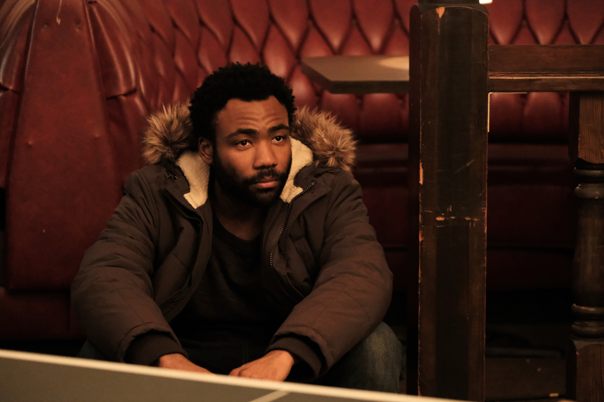 'Atlanta' Season 3 creator Donald Glover sits on the floor in a winter coat