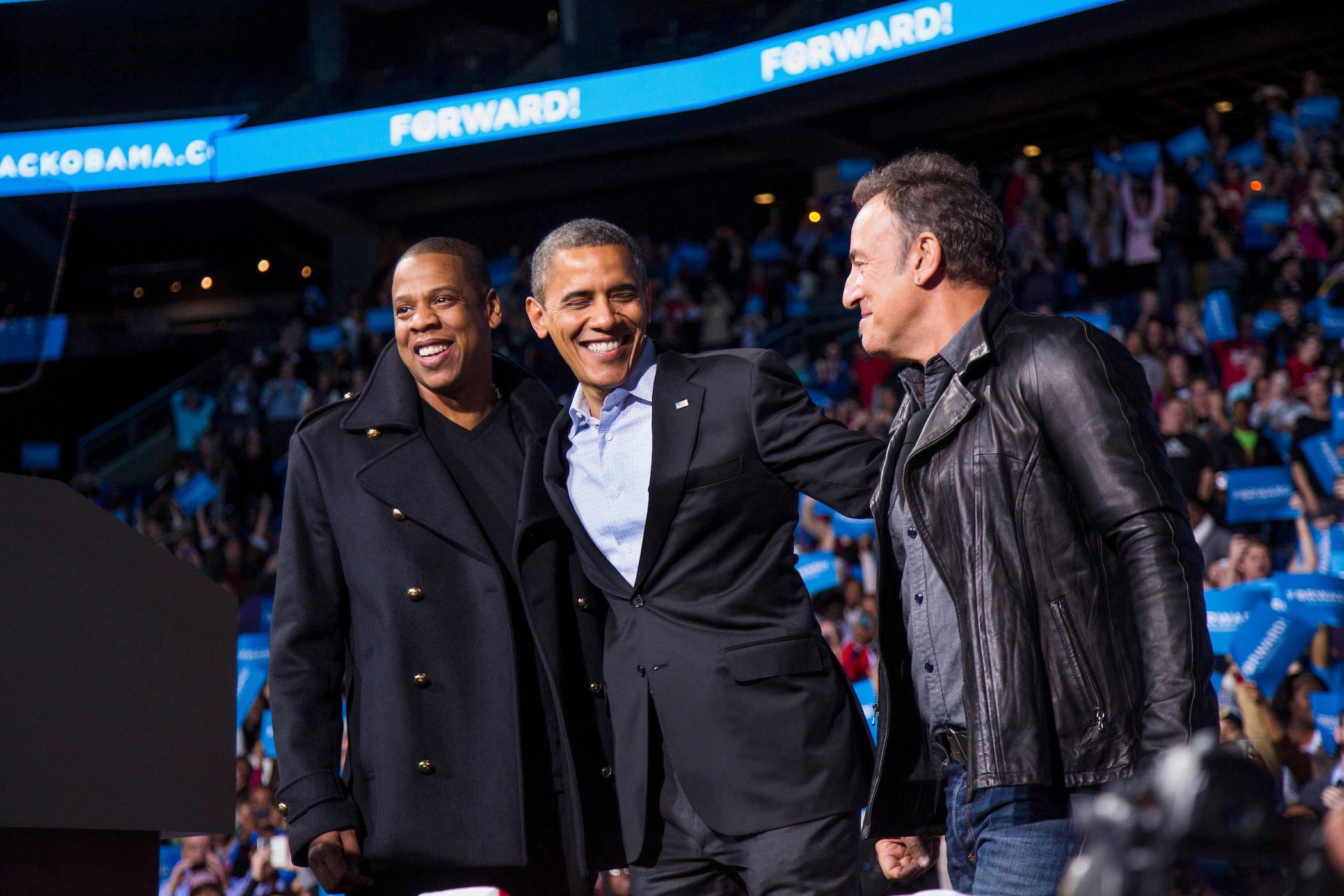 U.S. President Barack Obama stands on stage with rapper Jay-Z and musician Bruce Springsteen at an election campaign rally