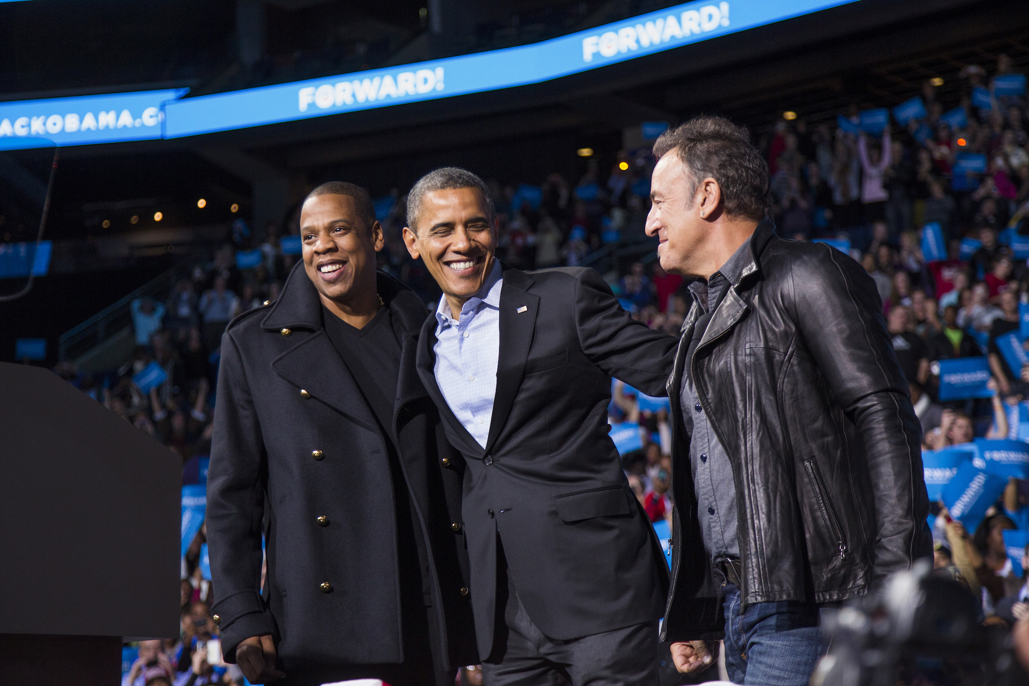 U.S. President Barack Obama stands on stage with rapper Jay-Z and musician Bruce Springsteen at an election campaign rally