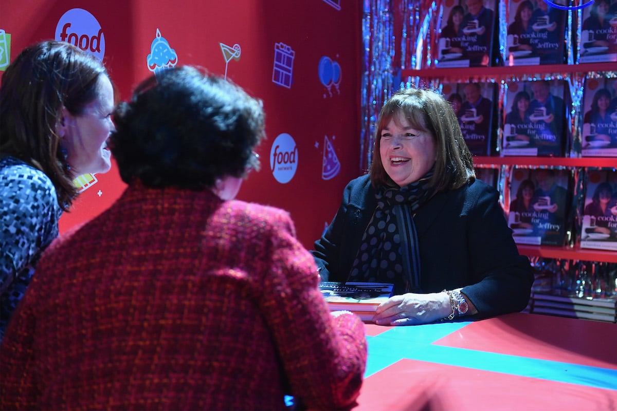 Barefoot Contessa Ina Garten smiles while sitting at a table talking to fans