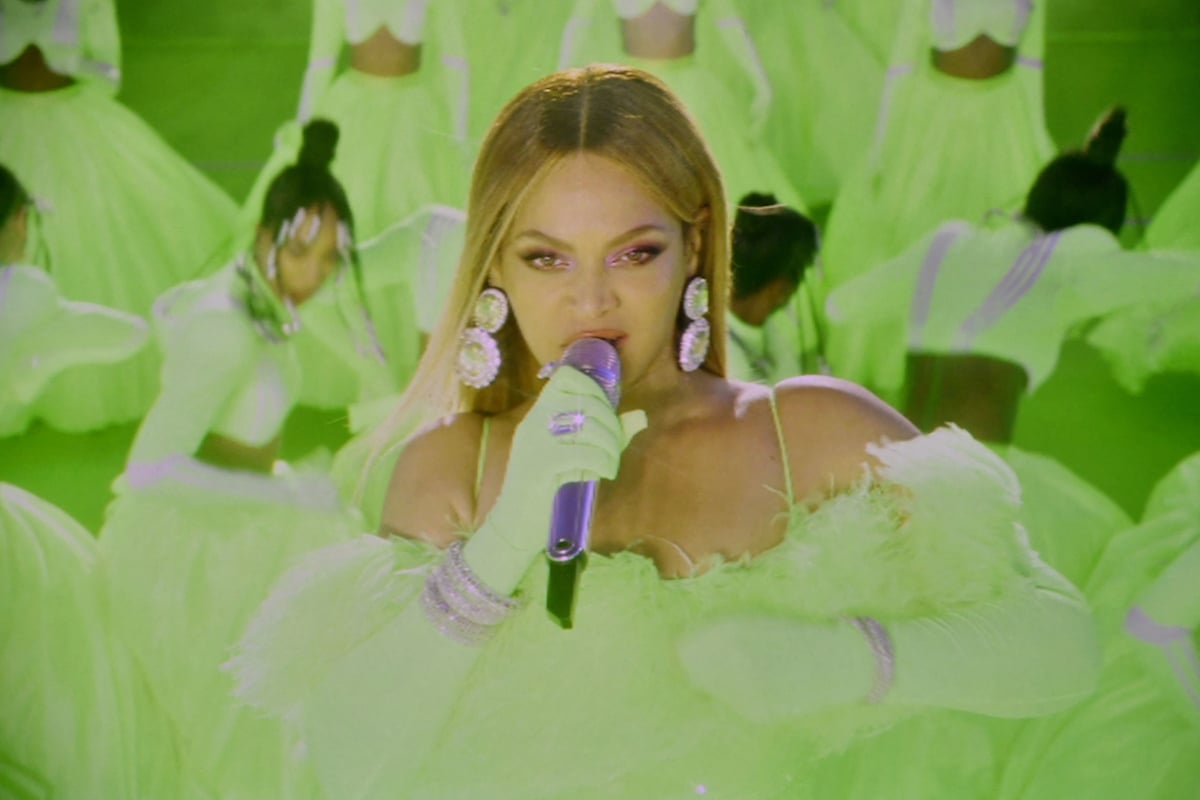 Beyonce sings into a microphone during the 94th Academny Awards wearing neon green in Compton, CA