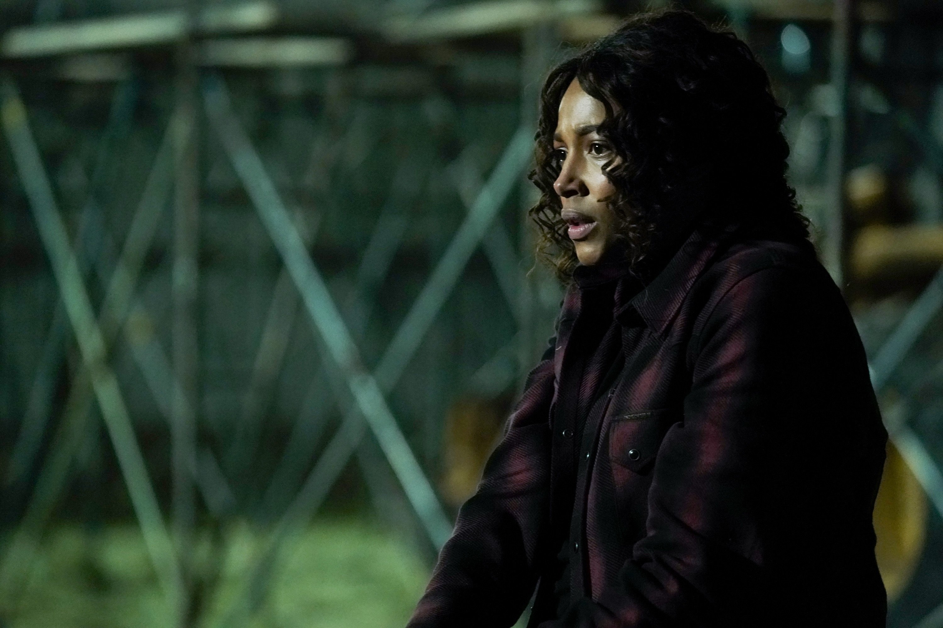 'Big Sky' cast member Kylie Bunbury as Cassie Dewell holding a gun in a dark area