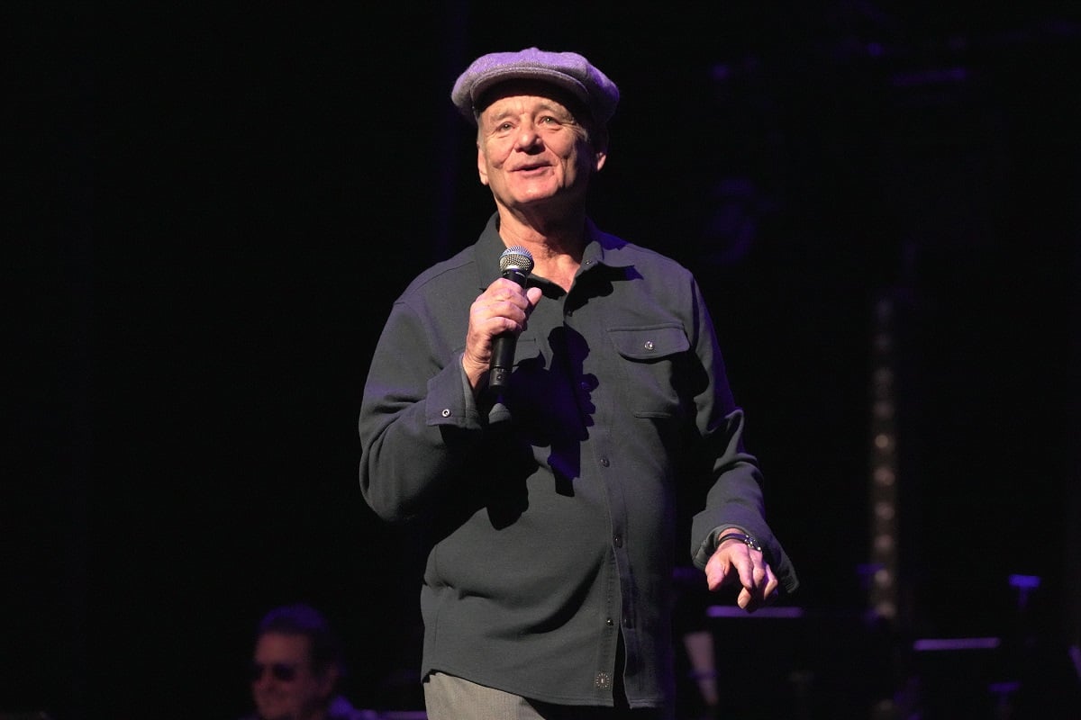 Bill Murray talking on stage while holding a microphone.
