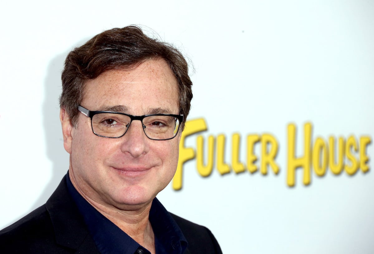 Bob Saget poses in front of the 'Fuller House' logo.