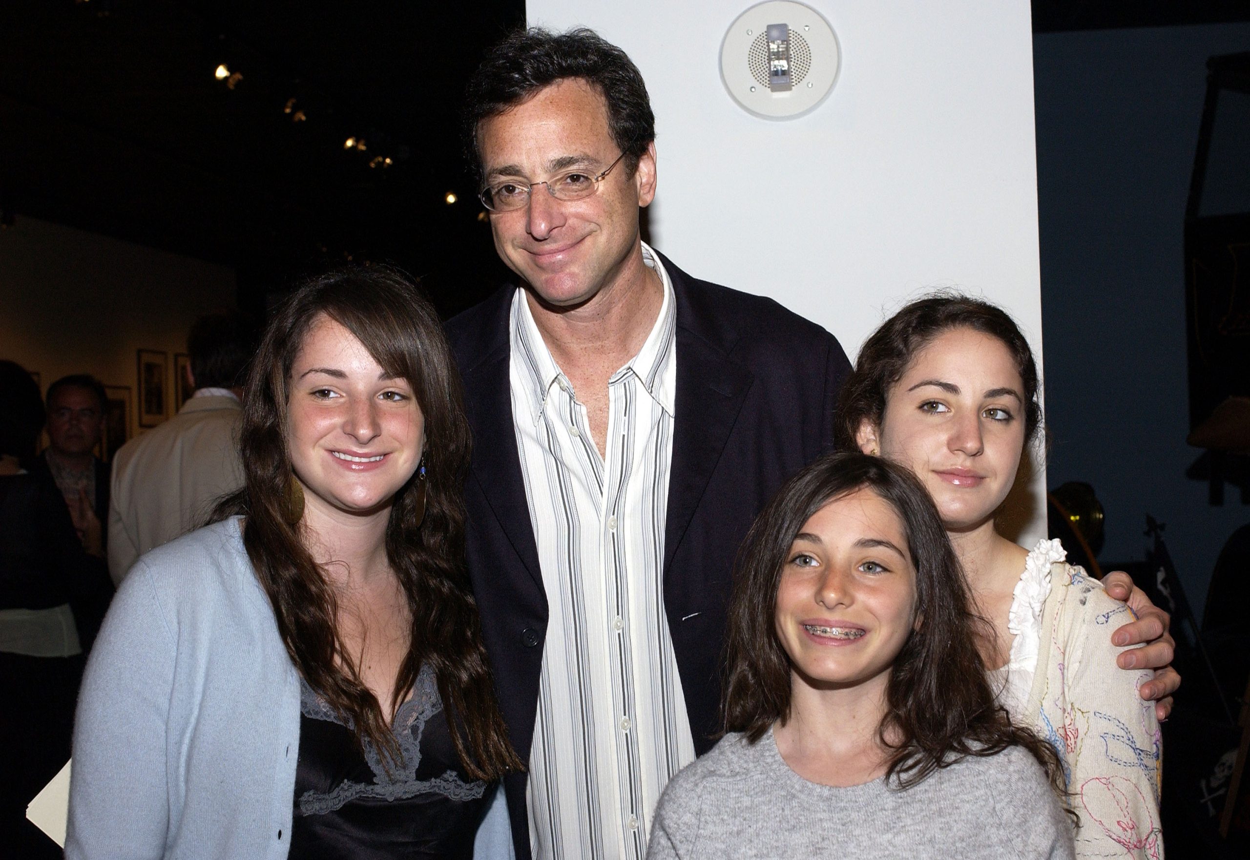 Bob Saget poses with his three daughters Lara, Jennifer, and Aubrey at an event.