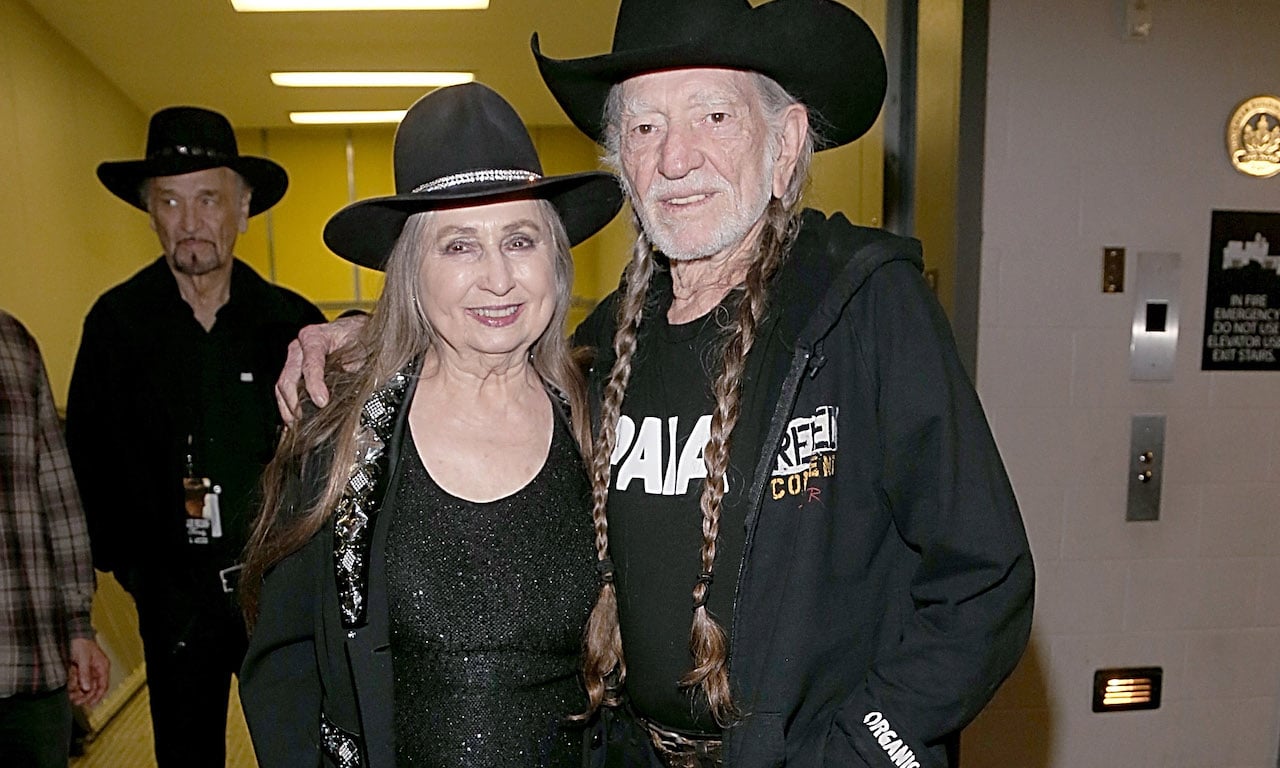 Willie Nelson pose for a picture, both wearing black cowboy hats