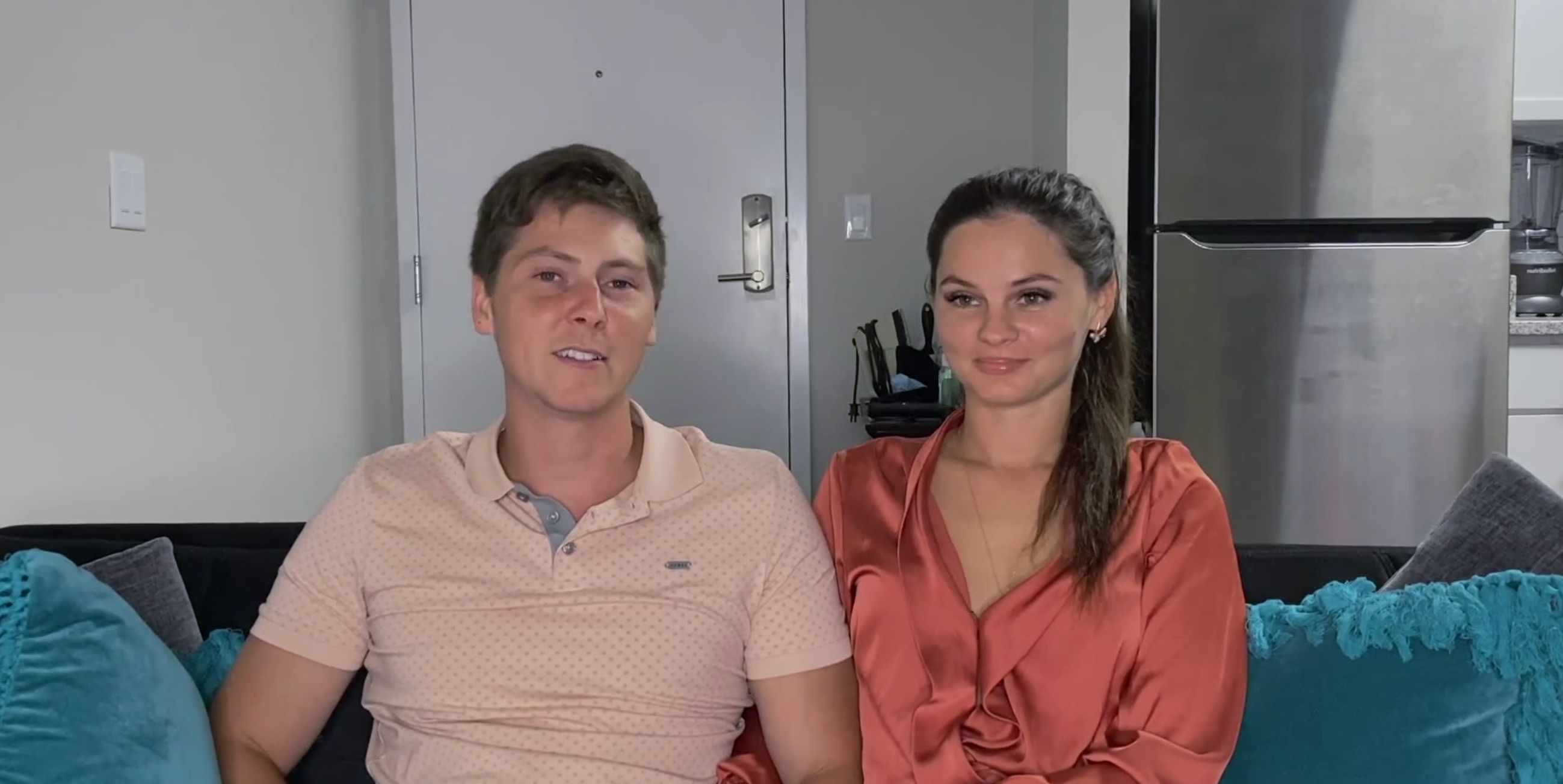 Brandon Gibbs and Julia Trubkina sitting on a couch together in their apartment on'90 Day Diaries'