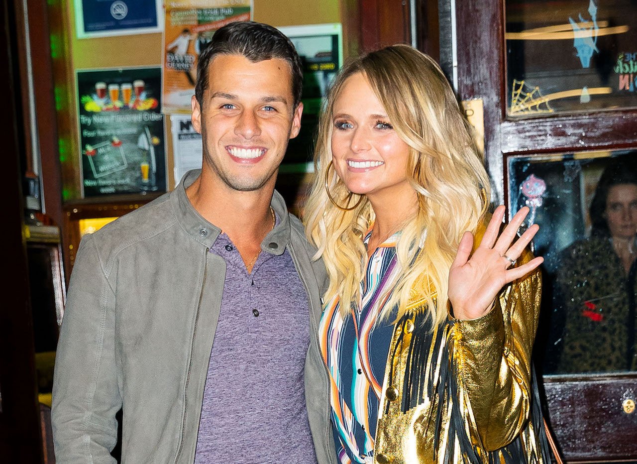 Brendan McLoughlin and Miranda Lambert in a gold jacket pose for photos in October 2019