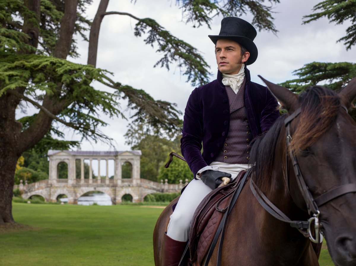 Jonathan Bailey as Anthony Bridgerton riding a horse and wearing a black hat.
