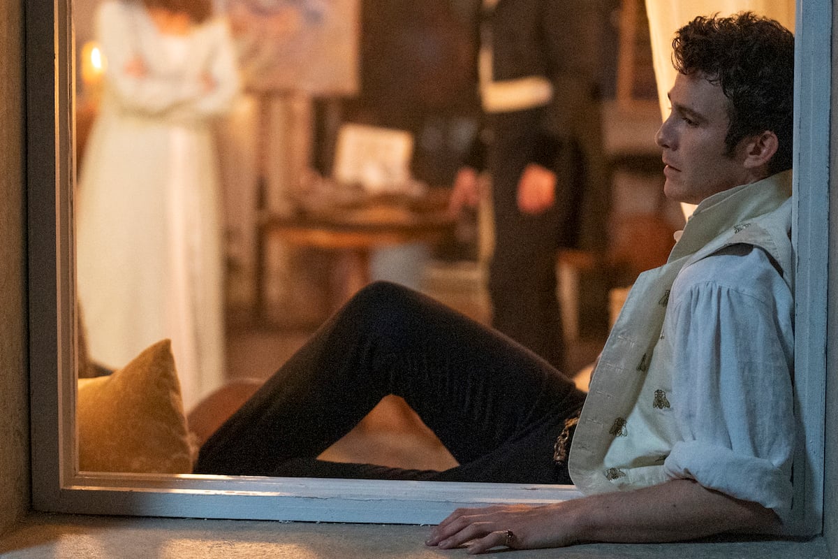 Luke Thompson as Benedict, sitting in a window, in 'Bridgerton' Season 2