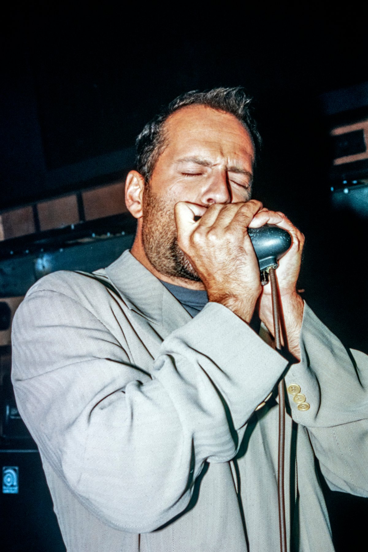 Bruce Willis plays the harmonica at the grand opening of Planet Hollwood in New York City.