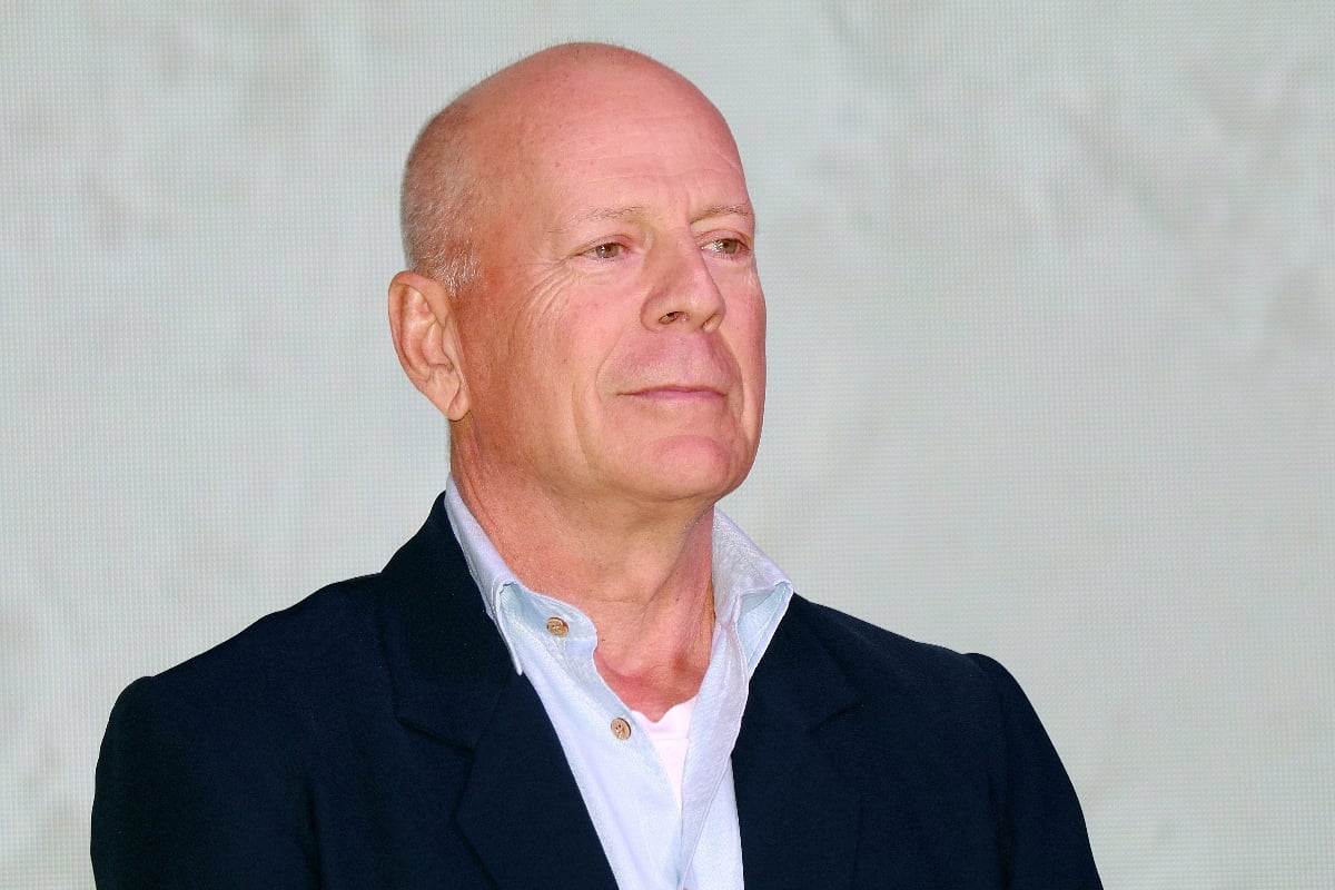 Bruce Willis wears a black suit and blue shirt while attending CocoBaba And Ushopal activity in Shanghai.
