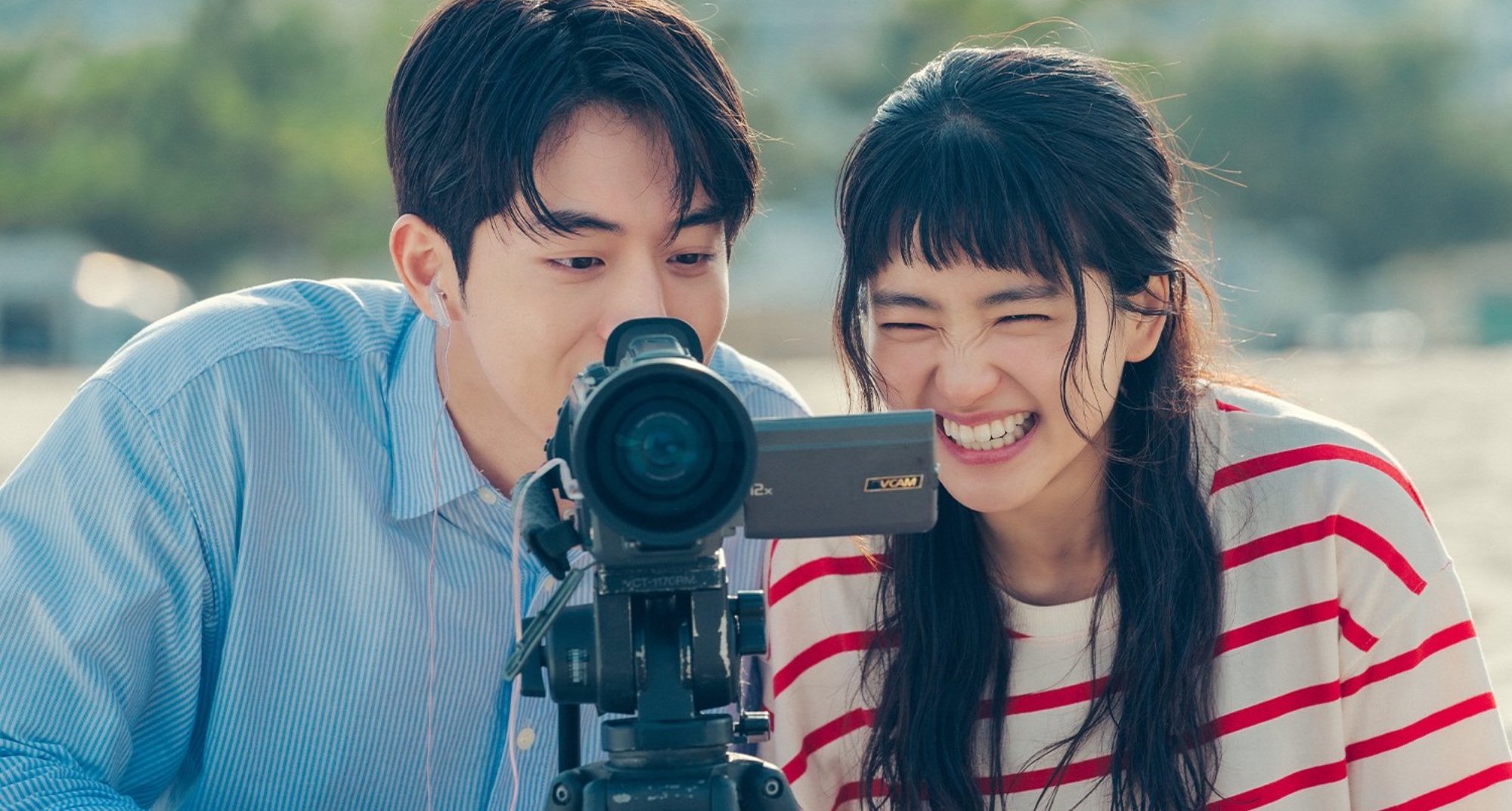 Characters Back Yi-jin and Nah Hee-do on 'Twenty-Five Twenty-One' smiling at camcorder in relation to age-gap romance.