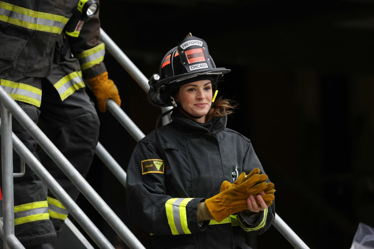 Daisy Betts as Rebecca Jones in Chicago Fire. Jones walks down the stairs wearing her firefighter gear.