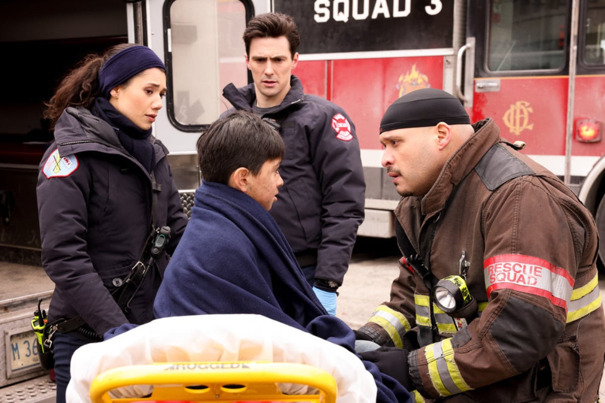 Hanako Greensmith as Violet, Jimmy Nicholas as Chief Hawkins, Joe Minoso as Joe Cruz in Chicago Fire. Joe talks with Javi after rescuing him from a burning building.