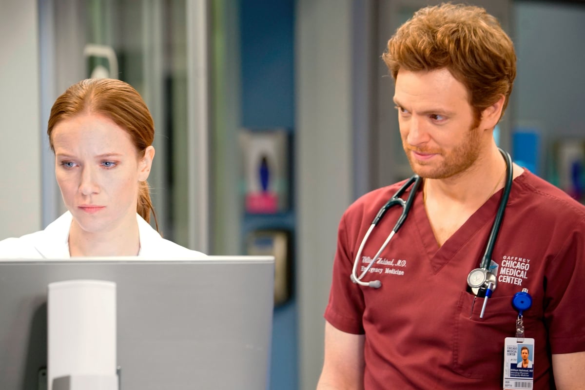 Jessy Schram as Dr. Hannah Asher and Nick Gehlfuss as Dr. Will Halstead Elizabeth in Chicago Med. Dr. Asher looks at a computer screen.