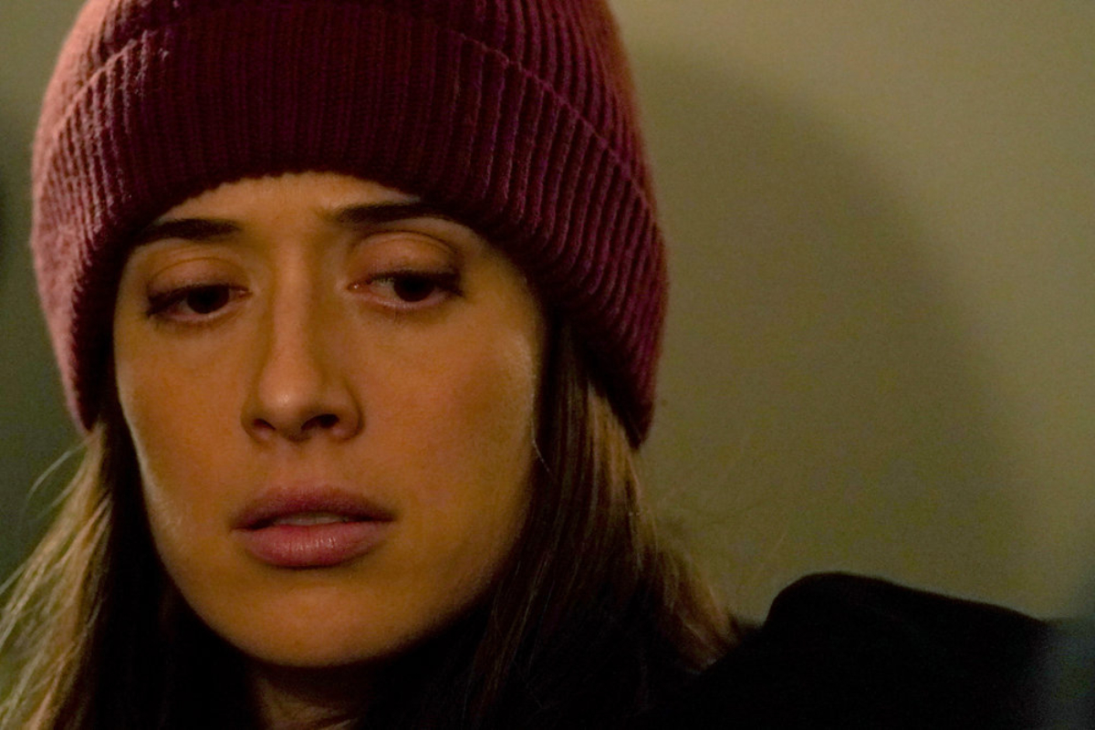 Marina Squerciati as Kim Burgess in Chicago P.D. Season 9. Kim Burgess wears a red hat and looks worried. 