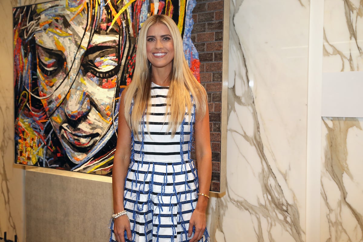 Christina Haack poses in a striped dress at an event.