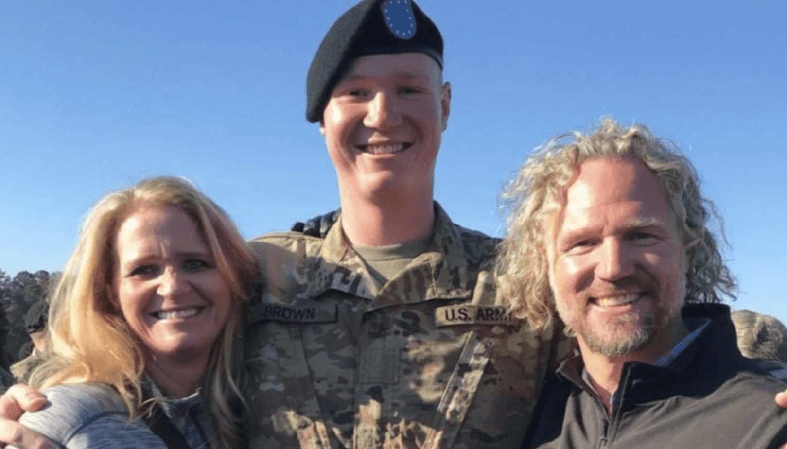 Christine Brown with Paedon Brown wearing an army uniform with Kody Brown standing together on ‘Sister Wives’.