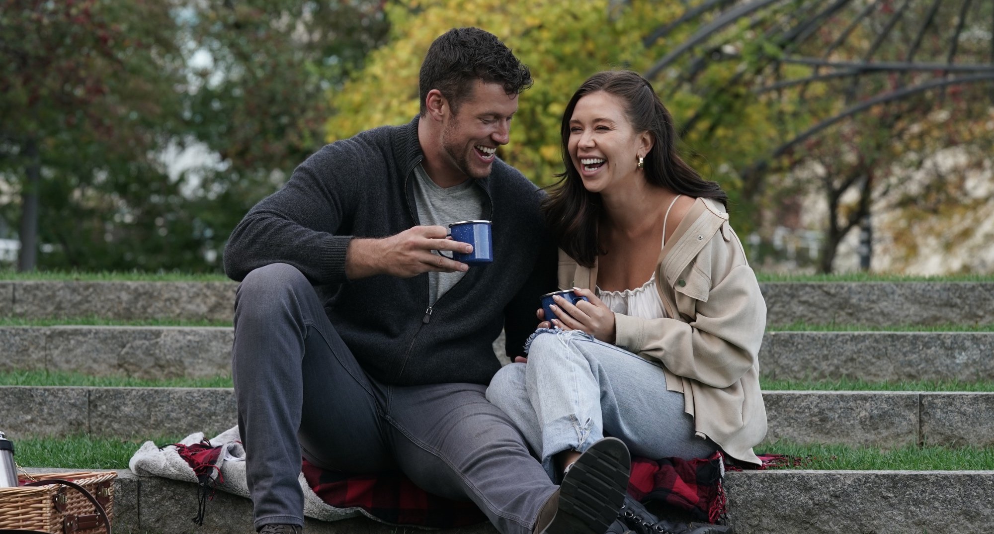 Clayton Echard and Gabby Windey on 'The Bachelor' sitting in park and laughing.