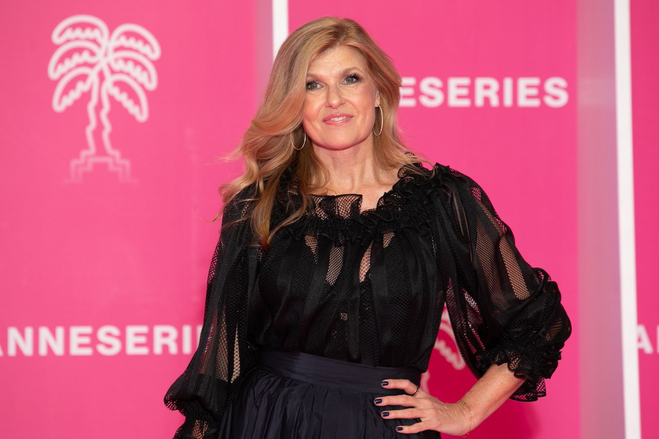 Connie Britton poses in black with one hand on her hip