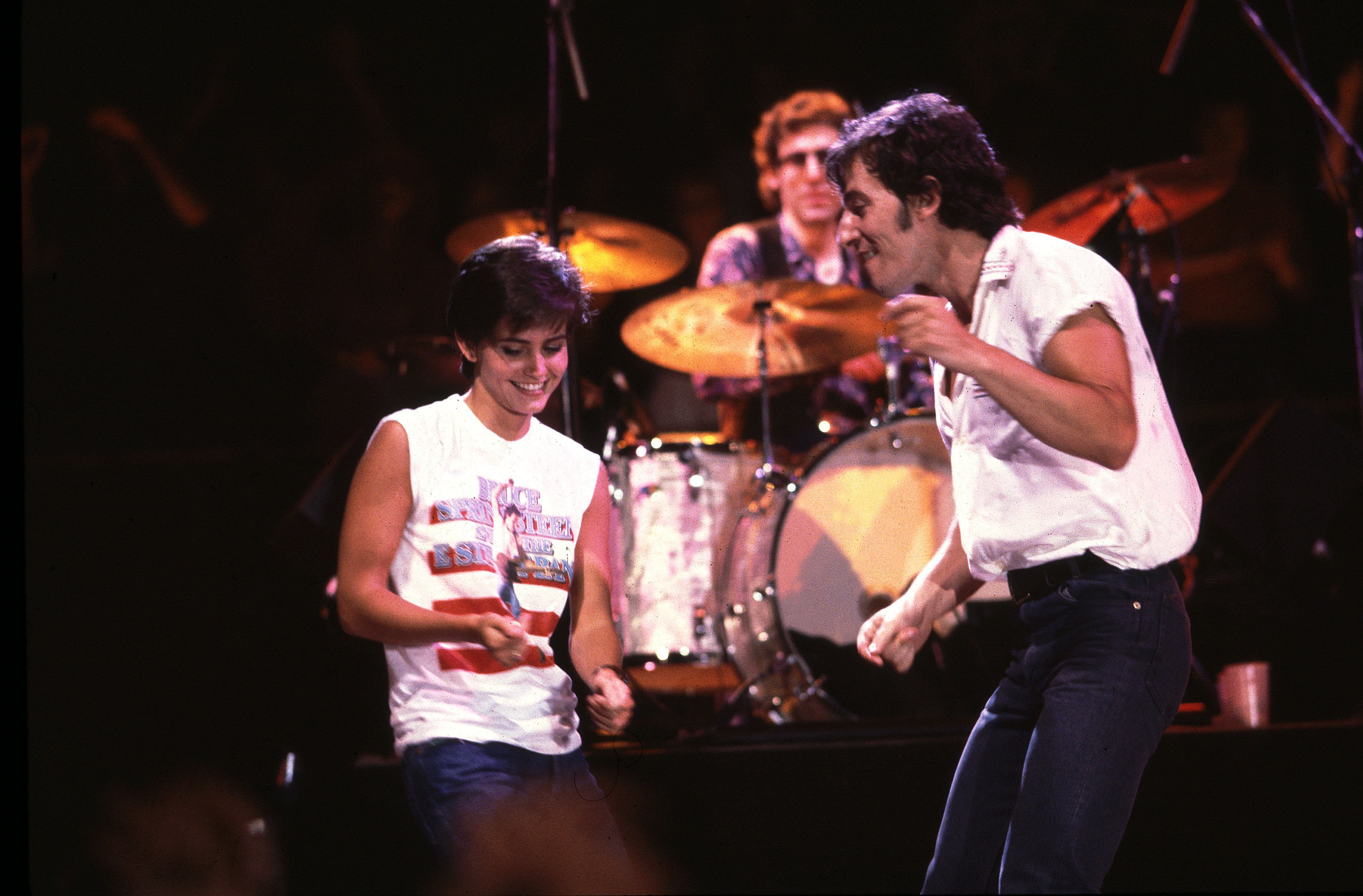 Courteney Cox and Bruce Springsteen dance in the dark on stage