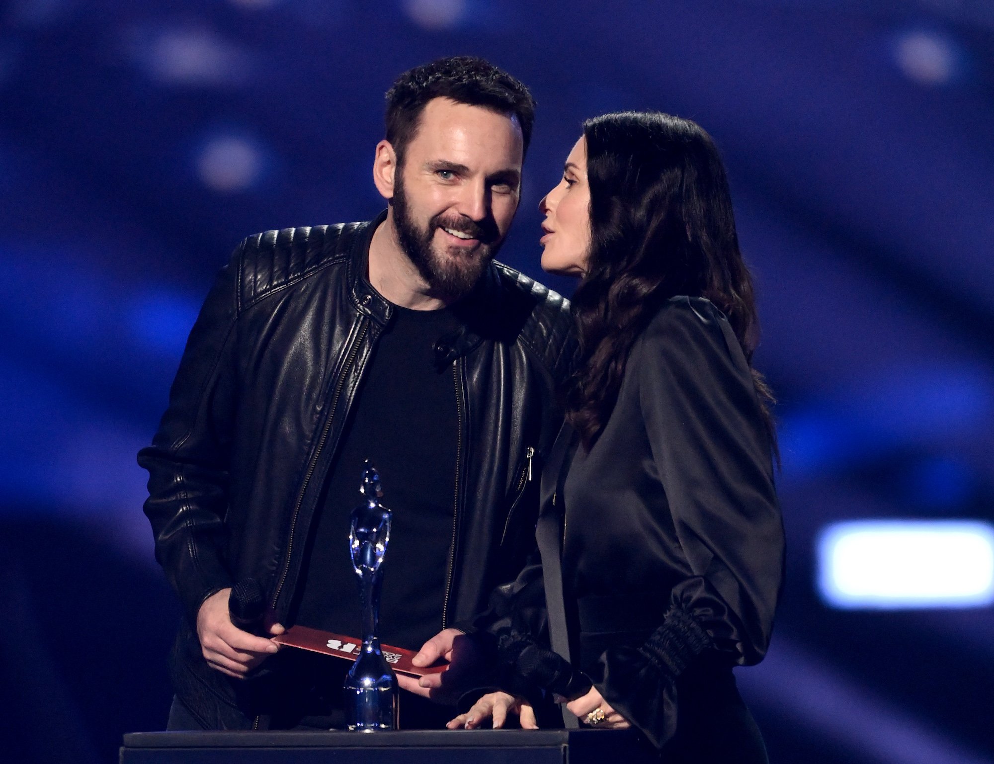 Courteney Cox whispers into Johnny McDaid's ear