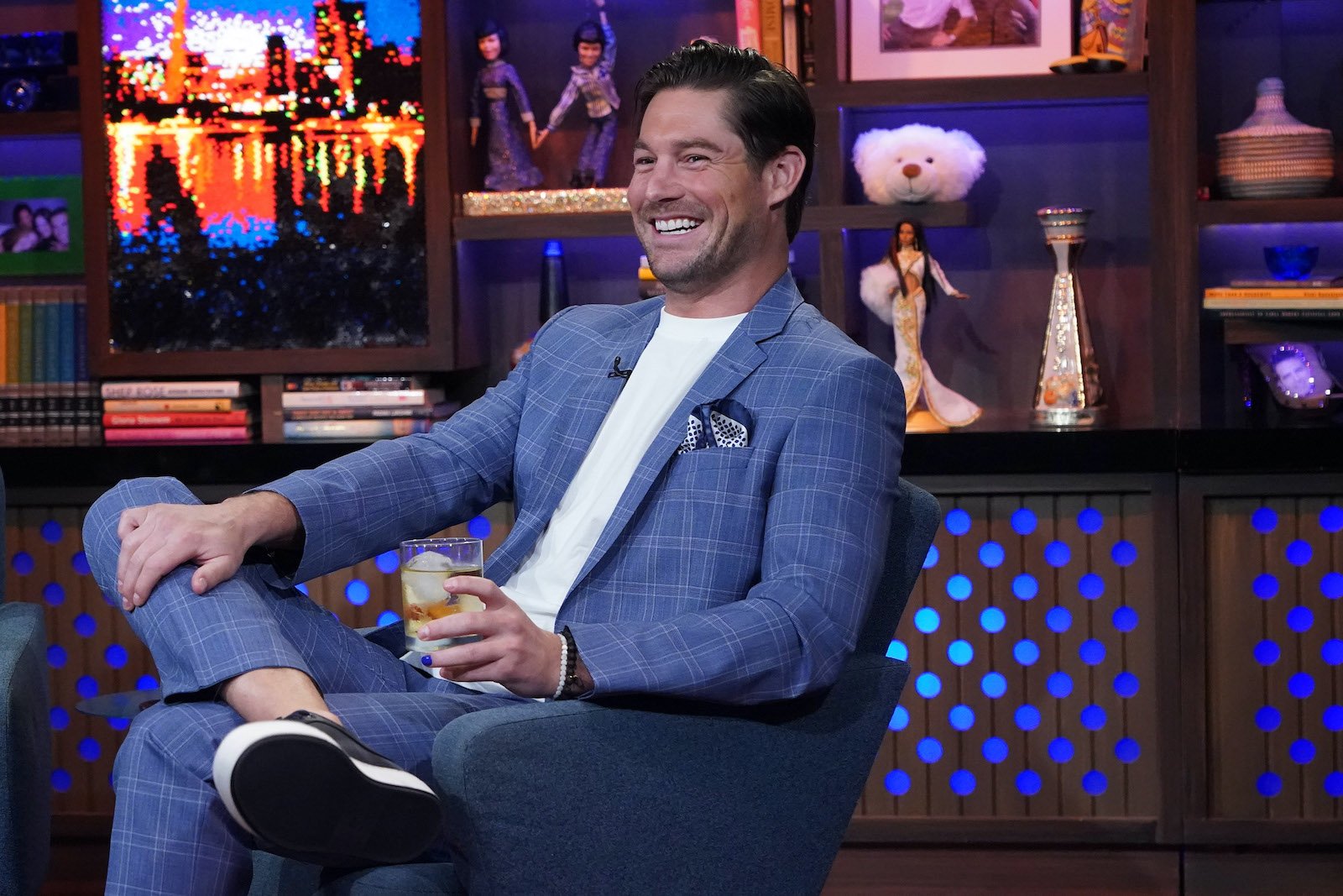 Craig Conover from 'Southern Charm' holds a cocktail and smiles while at 'WWHL'