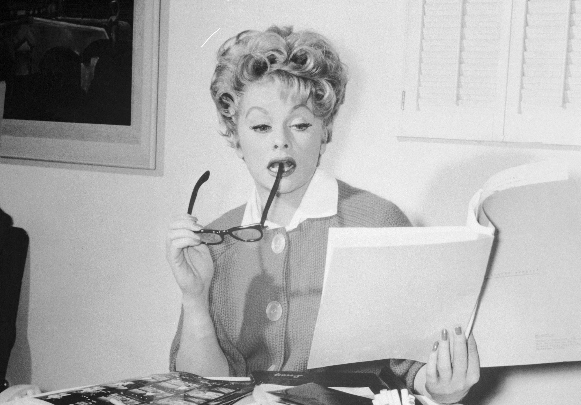 Lucille Ball reads scripts at her desk at Desilu Productions in 1967