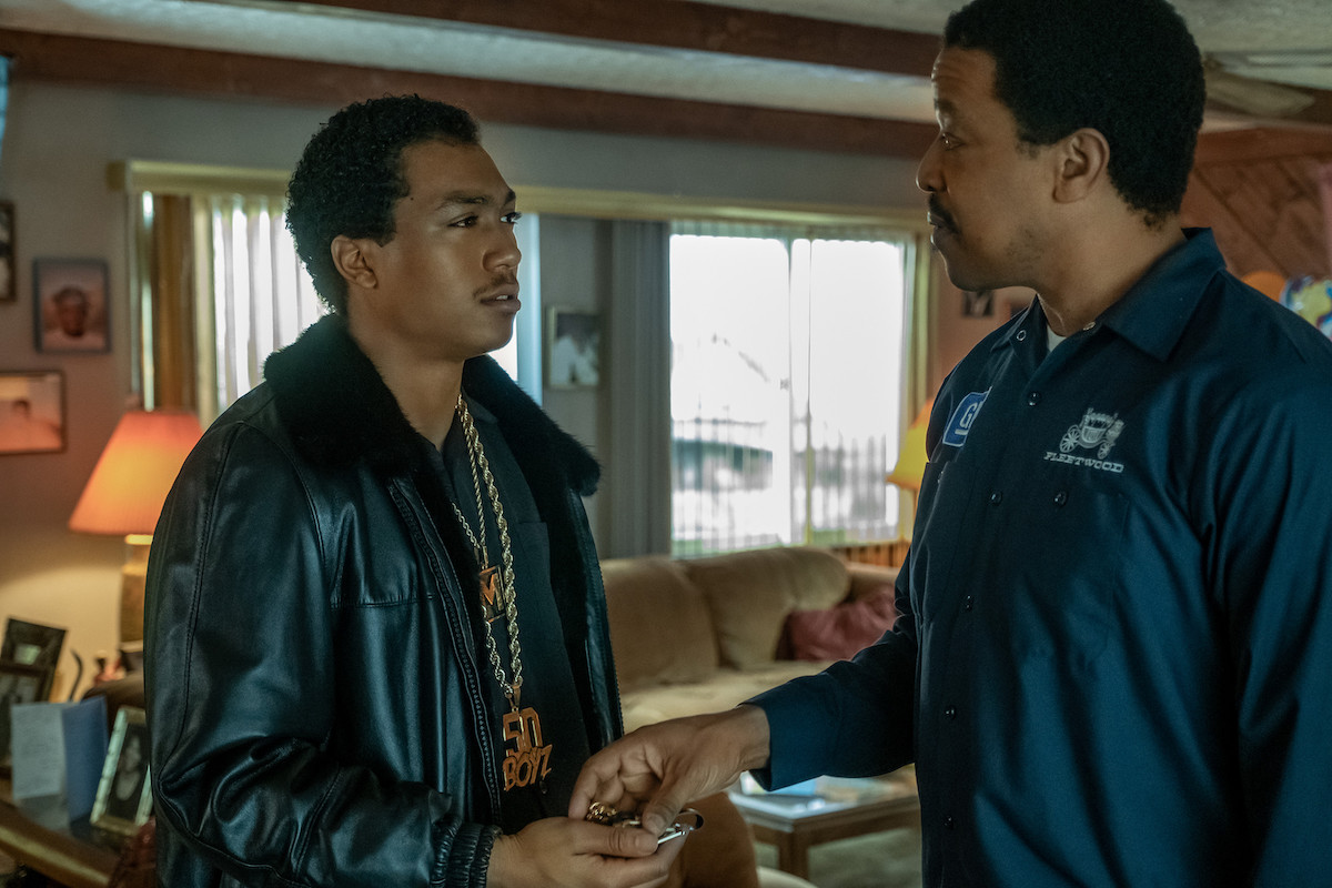 Demetrius "Lil Meech" Flenory Jr as Demetrius "Big Meech" Flenory wearing a leather coat and a chain and Russell Hornsby as Charles Flenory wearing a work uniform in 'BMF'