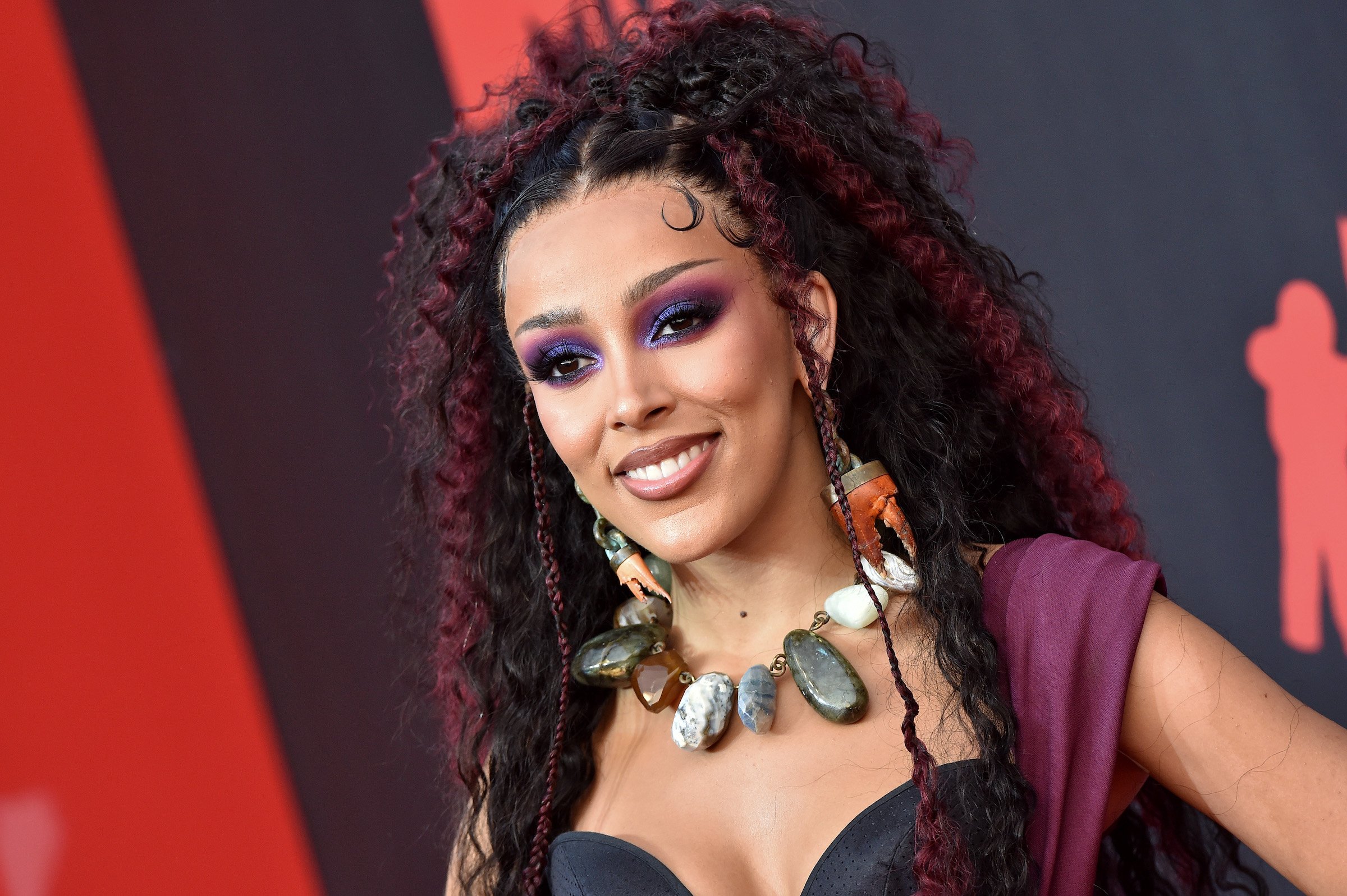 Doja Cat on a red carpet wearing black and purple hair