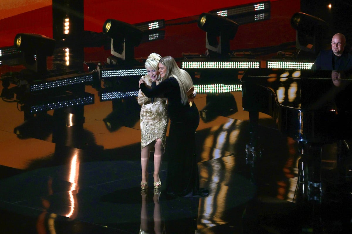 Dolly Parton and Kelly Clarkson hug onstage during the 2022 Academy of Country Music Awards