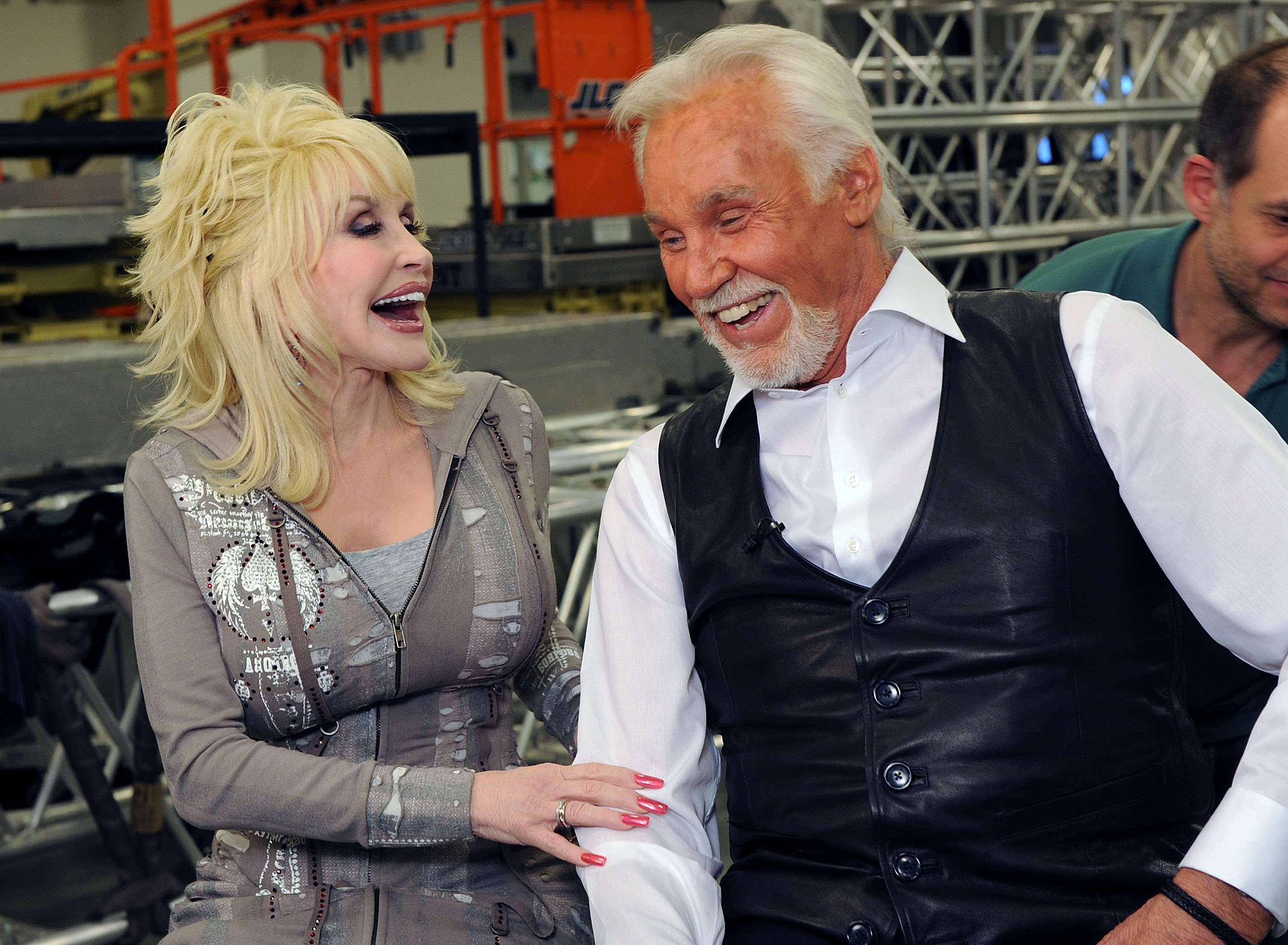 Dolly Parton and Kenny Rogers laugh during an interview. 