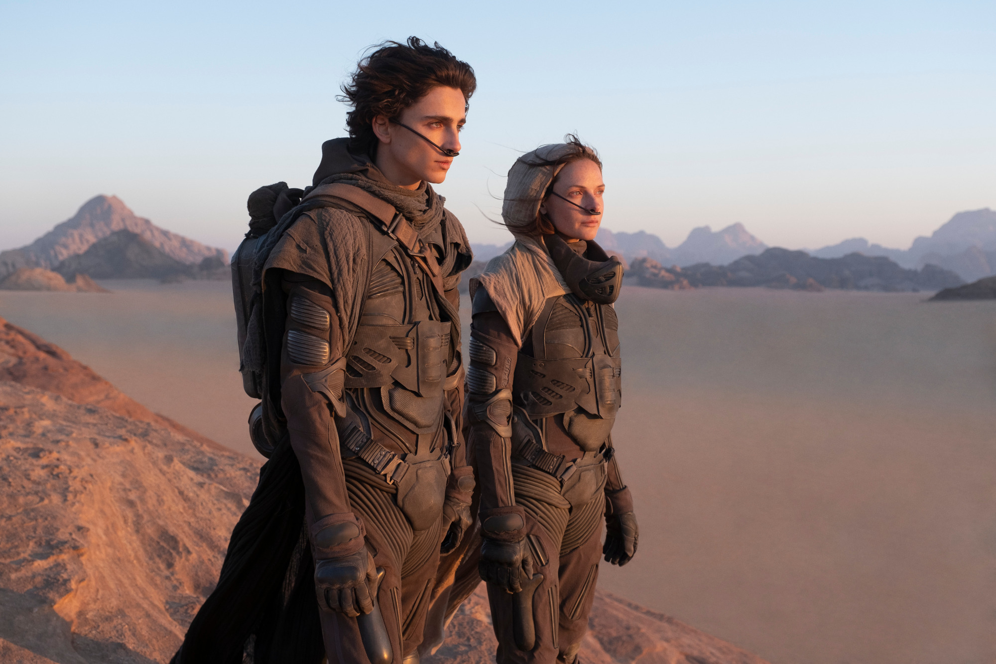 2022 Best Picture nominee 'Dune.' The image features Timothée Chalamet as Paul Atreides and Rebecca Ferguson as Lady Jessica Atreides. They're standing in the desert.